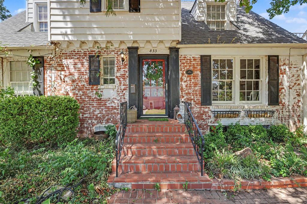 There's so much to love about this 1935 brick cottage in Crown Heights, tucked beneath mature shade trees, instantly inviting from the curb. A red front door and brick steps lead you into a home that beautifully balances historic charm with character-rich details. Original hardwood floors, rich wood trim, and crown molding carry through the main living spaces, while a cozy living room fireplace anchors it all.The galley-style kitchen features white cabinetry, granite counters, a mosaic tile backsplash, and a farmhouse sink, with a built-in wall-mounted double oven and microwave, a beverage fridge, and a gas cooktop set into the peninsula island beneath a sleek hood vent. It flows right into the dining area, with an eat-in bar for casual mornings. A bright sunroom off the side of the home makes a perfect reading nook or work-from-home spot, filled with natural light and views of the yard.The primary suite, on the first floor, is a true retreat with a spa-like bath featuring a soaking tub, a walk-in shower, and a double vanity. Several additional bedrooms offer versatility for family, guests, or hobbies, tucked under charming dormered ceilings with original character intact. Downstairs, a finished basement offers even more flexible living space, complete with laundry.Outside, the fenced backyard is made for gathering, with a spacious patio for entertaining and a storage shed, plus an attached single-car garage for convenience.This is a home with real character in one of Oklahoma City's most beloved neighborhoods. Schedule your showing today!