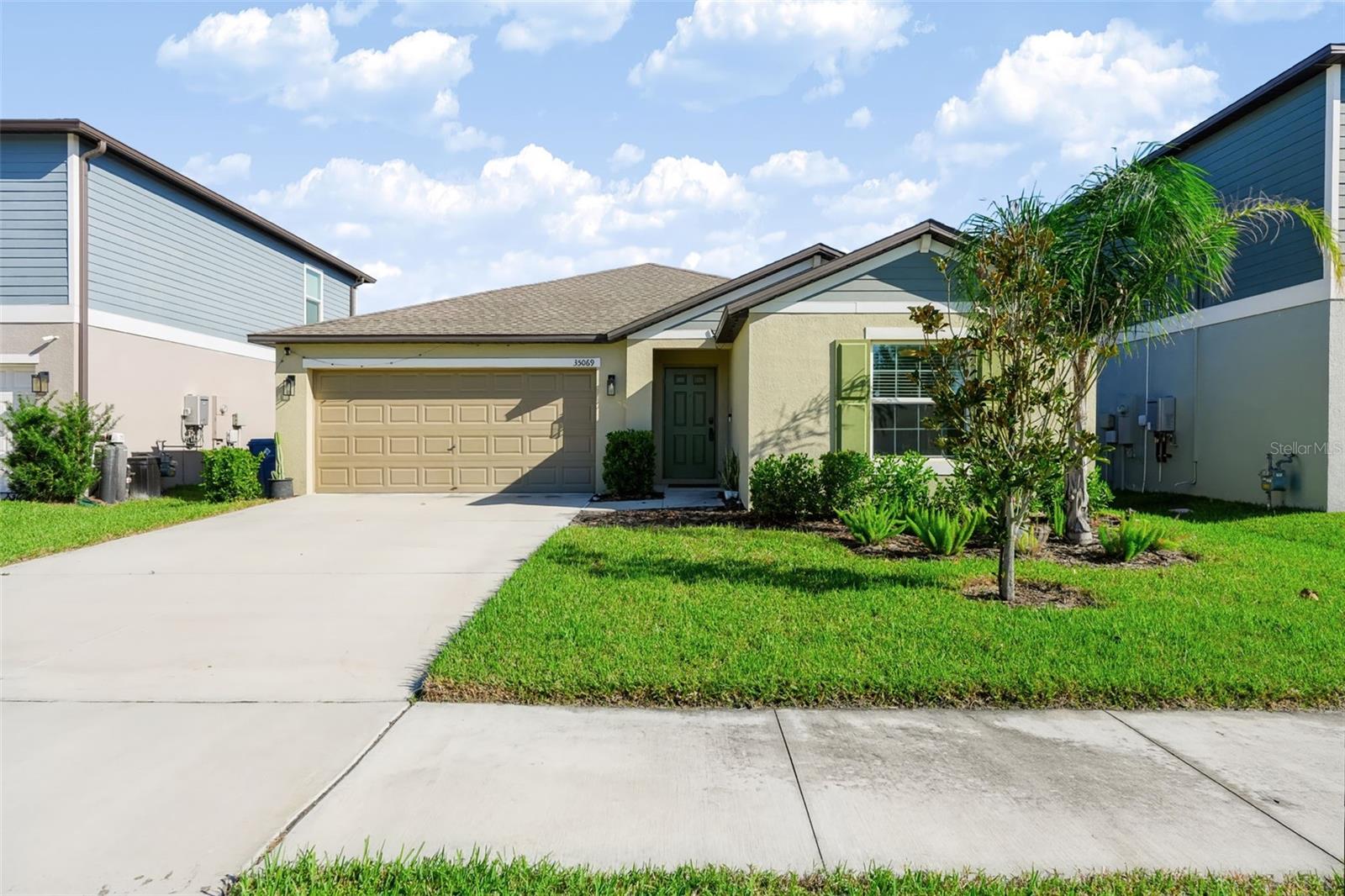 Virtually Staged. Short Sale. Welcome to this beautifully designed four-bedroom, two-bathroom home in the desirable community of Childers at Two Rivers in Zephyrhills! Built in 2023, this 1,939-square-foot home offers an open floor plan and a comfortable layout designed for everyday living and entertaining. A welcoming foyer leads into the spacious main living areas, where the living room, dining area, and kitchen flow seamlessly together. The kitchen features stone countertops, stainless steel appliances, a walk-in pantry, and a center island offering additional prep space and casual dining, complemented by updated fixtures and tile flooring throughout the main living areas. The split-bedroom floor plan provides added privacy, with the spacious primary suite featuring a private bathroom with a dual-sink stone-top vanity, walk-in shower, private water closet, and walk-in closet. Three additional bedrooms offer comfortable accommodations, each with carpet flooring and ceiling fans, and share a full bathroom with a tub and shower combination. A dedicated interior laundry room adds everyday convenience, while the garage features custom shelving for additional storage. Step outside to enjoy the fenced backyard, complete with an extended paver patio, covered pergola, and fire pit, creating an inviting space for outdoor dining, relaxing, and gathering with friends. Residents enjoy community amenities including a clubhouse, swimming pool, sports courts, and playground, along with exclusive club access at The Landing in a neighboring phase of the community, available for an optional membership fee. Conveniently located near shopping, dining, and entertainment, including Tampa Premium Outlets and The Shops at Wiregrass! Schedule your showing today!