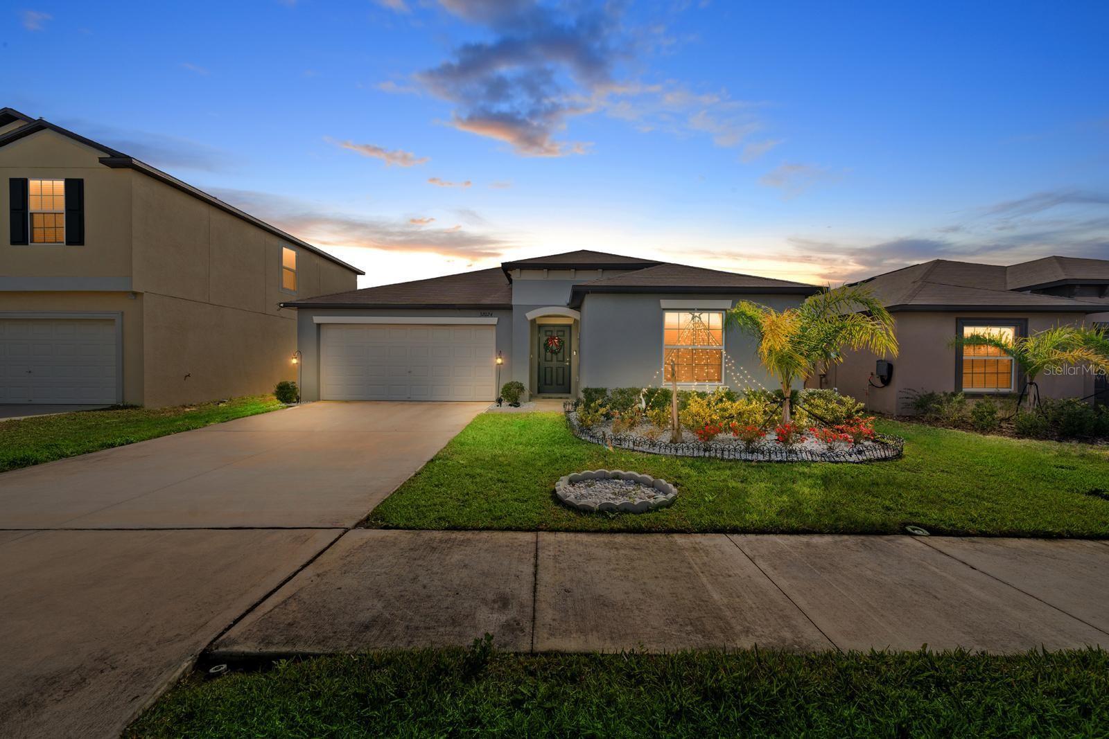 Built in 2023, this impressive 4-bedroom, 2-bath, 2-car garage home offers 1,936 sq ft of thoughtfully designed living space and is tucked away on a quiet cul-de-sac in the highly desirable Mirada master-planned community in San Antonio, Florida. From the moment you arrive, you’ll appreciate the elongated driveway accommodating up to six vehicles, fresh exterior landscaping with white rock perimeter accents, and a fully fenced backyard with new sod—perfect for privacy and outdoor enjoyment.Inside, the open floor plan seamlessly connects the family room, dining area, and kitchen, making it ideal for both everyday living and entertaining. Tile flooring spans the main living areas, while the bedrooms are comfortably carpeted. The kitchen is beautifully appointed with all-wood cabinetry featuring pull-out drawers, granite countertops, a stylish backsplash, recessed lighting, and stainless steel appliances—all included. A water softener system and reverse osmosis drinking water system add everyday convenience and quality.Just off the dining area, double sliding glass doors lead to a large paved lanai featuring a covered insulated aluminum roof, outdoor ceiling lights, and ceiling fans—an ideal space to relax or host gatherings year-round.The owner’s suite is privately situated and offers a serene retreat, complete with a spacious walk-in closet and a spa-like bathroom featuring dual vanities and a glass-enclosed shower. Three additional bedrooms provide flexibility for guests, family, or a home office. The epoxy-coated garage floor adds a polished touch to the spacious two-car garage. (Washer and dryer do not convey.)Community Highlights: Mirada is home to the iconic 15-acre lagoon—the largest in the nation, delivering a true beach-style lifestyle with swimming, kayaking, paddleboarding, and sandy relaxation. Residents enjoy scenic multi-modal paths, nature trails, a playground, and a dog park. Conveniently located just minutes from I-75, Mirada offers easy access to downtown Tampa while maintaining a peaceful suburban setting!