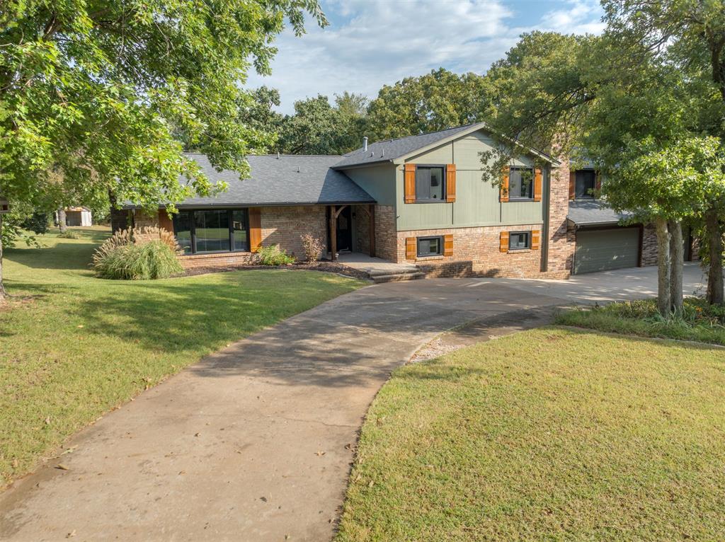Tucked away on nearly 1.5 acres with tall, mature trees, this home feels like your own private retreat that's centrally located in Edmond with easy access to I-35, shopping, and dining. 
Walk through the front door and you’ll notice the character right away. Big windows, warm beams, and an updated kitchen that makes cooking and gathering enjoyable. The living room is anchored by a fireplace with a brick surround and book shelves. While sitting on the couch, you have views of the trees, pool, and large deck. The primary suite is something special. It’s spacious, peaceful, and has that treehouse feel you can’t find anywhere else. Wake up to sunlight filtering through the trees, step out onto your private balcony, and enjoy the quiet. Curl up by your own fireplace on cooler nights and enjoy the luxury of a closet that can actually hold your belongings. Downstairs is all about connection and fun. Whether it’s game night, movie marathons, or a holiday gathering, the bonus room with its own bar, bathroom, and fireplace makes hosting effortless and having fun a normal part of your day. And then there’s the backyard. A big deck for summer cookouts, a pool for long afternoons that turn into evenings, and room to spread out, breathe, and live the good life. If you’ve been looking for something with character, space, and that “this is it” feeling, you just found it!