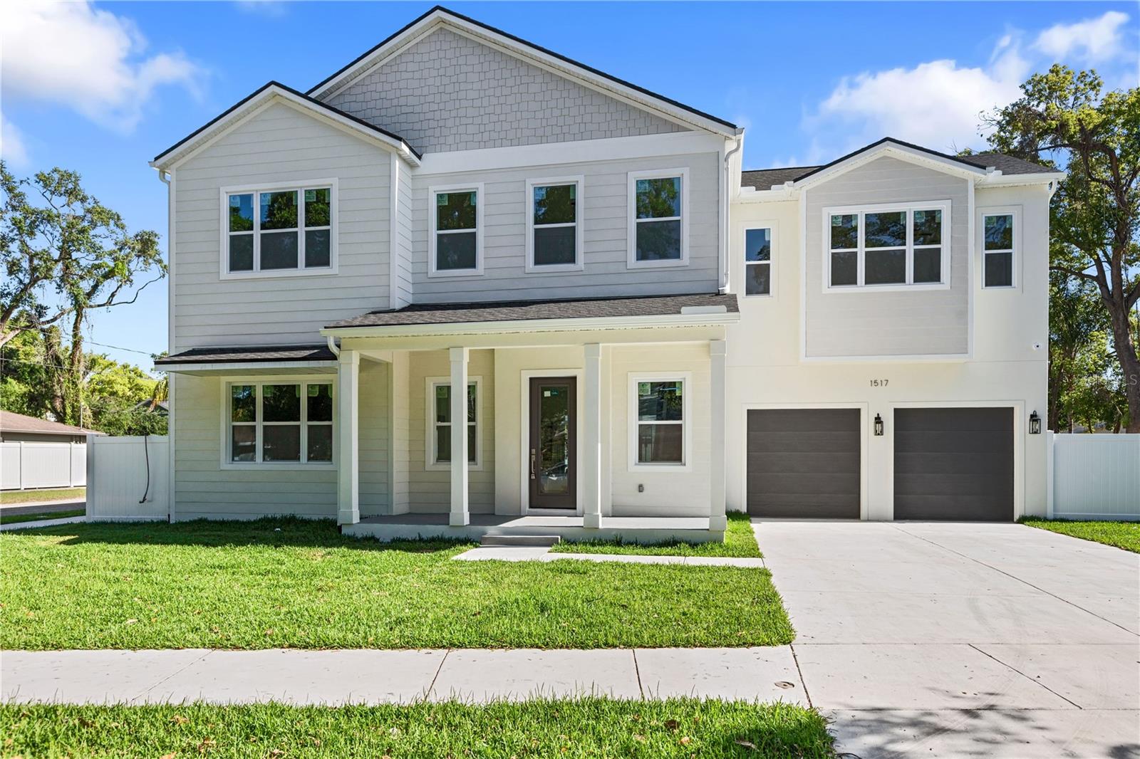 517 Escort Ave is a newly built modern residence that balances clean architectural lines with a warm, organic interior aesthetic. The exterior sets the tone immediately: layered siding textures, a soft coastal-inspired palette, and a welcoming front porch framed by crisp white columns. The symmetry, the roofline, and the oversized windows give the home a refined, contemporary presence on the street — understated yet undeniably upscale.Inside, a dramatic two-story atrium floods the main living area with natural light. The vertical volume, black metal railings, and open sightlines create a sense of scale that feels both architectural and inviting. The living room’s soft neutral furnishings, textured rug, and warm wood accents complement the wide-plank French oak flooring that runs throughout the home. Every detail — from the matte black fixtures to the curated artwork — reinforces a cohesive, modern design language.The kitchen is a standout moment. Light wood cabinetry, brass hardware, and a clean white tile backsplash create a soft, Scandinavian-inspired palette. The wood island adds warmth and functionality, while the pendant lighting introduces a sculptural touch. Stainless steel appliances, a large window over the sink, and thoughtful styling make the space feel elevated yet comfortable — the kind of kitchen that photographs beautifully and lives even better.The dining area continues the indoor-outdoor connection with large sliding glass doors that open to the backyard. Natural light pours in, highlighting the round wood table, modern seating, and layered textures. It’s a space designed for real living — morning coffee, family dinners, or hosting friends with the doors open to the breeze.Upstairs, the primary suite is a serene retreat. Soft natural light, a calming neutral palette, and views of greenery create a restorative atmosphere. The ensuite bathroom features warm vertical tile, a modern vanity with black fixtures, and a boutique-hotel feel. Additional bedrooms — including one with its own ensuite — offer flexibility for family, guests, or a dedicated office. The loft adds another layer of usable space, ideal for a lounge, play area, or creative workspace.Every bathroom in the home is finished with intention: warm tile selections, clean lines, modern lighting, and a balance of natural materials with matte black accents. Even the powder room feels curated, with its vertical accent wall and minimalist fixtures.Premium Construction & Technology Upgrades1517 Escort Ave is equipped with impact-rated windows and doors, providing enhanced safety, storm protection, energy efficiency, and noise reduction. The home also includes a full 1-2-10 builder warranty — one year of workmanship, two years of major systems, and ten years of structural coverage — offering long-term peace of mind. Modern connectivity is built in with Cat 6 ethernet wiring throughout, Wi-Fi extender locations, and full security-camera prewiring, giving the home a true smart-ready infrastructure.With 2,530 square feet of living space, a two-car garage, and a quiet location with quick access to Tampa’s key destinations, this residence delivers a refined living experience with the ease and confidence of new construction. Plans and a full finishes lookbook are attached for reference.