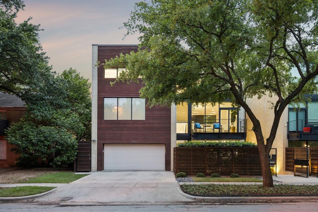 Set within the Travis Walk-Katy Trail district and conceptualized with the art connoisseur in mind, 4321 Travis Street is no ordinary townhome. Across three levels, this residence captures the allure of urban living — design that’s fluent in both comfort & finesse and genuine privacy that places the energy of the city just beyond its doorstep. The exterior is well-considered: taupe masonry, warm wood cladding, floor-to-ceiling windows that glow at dusk. Inside, the double-height main living area sets the tone — exposed brick, a floating steel staircase, hardwood floors, and natural light that moves through the residence with intention. Generously scaled, but not excessive. The kitchen is precise. White flat-front cabinetry ascends to the ceiling, a substantial island anchors the space, and professional-grade appliances bring function & form into the same conversation. The dining room opens directly to a private courtyard with a water feature, fireside seating, and mature trees that offer a quiet departure from the pace of the city.The second-floor primary suite feels understated yet complete. A private balcony and walnut-paneled dressing room amplify the home’s thoughtful sophistication. A coffee bar with dual refrigerator doors and distinct his-and-her shower areas add pockets of convenience. The third level offers flexibility for all phases of life: a mirrored fitness room, entertainment den, and two additional ensuite bedrooms. The elevator that serves all three levels underscores the home’s ease of use, and a gated motor court delivers peace of mind.