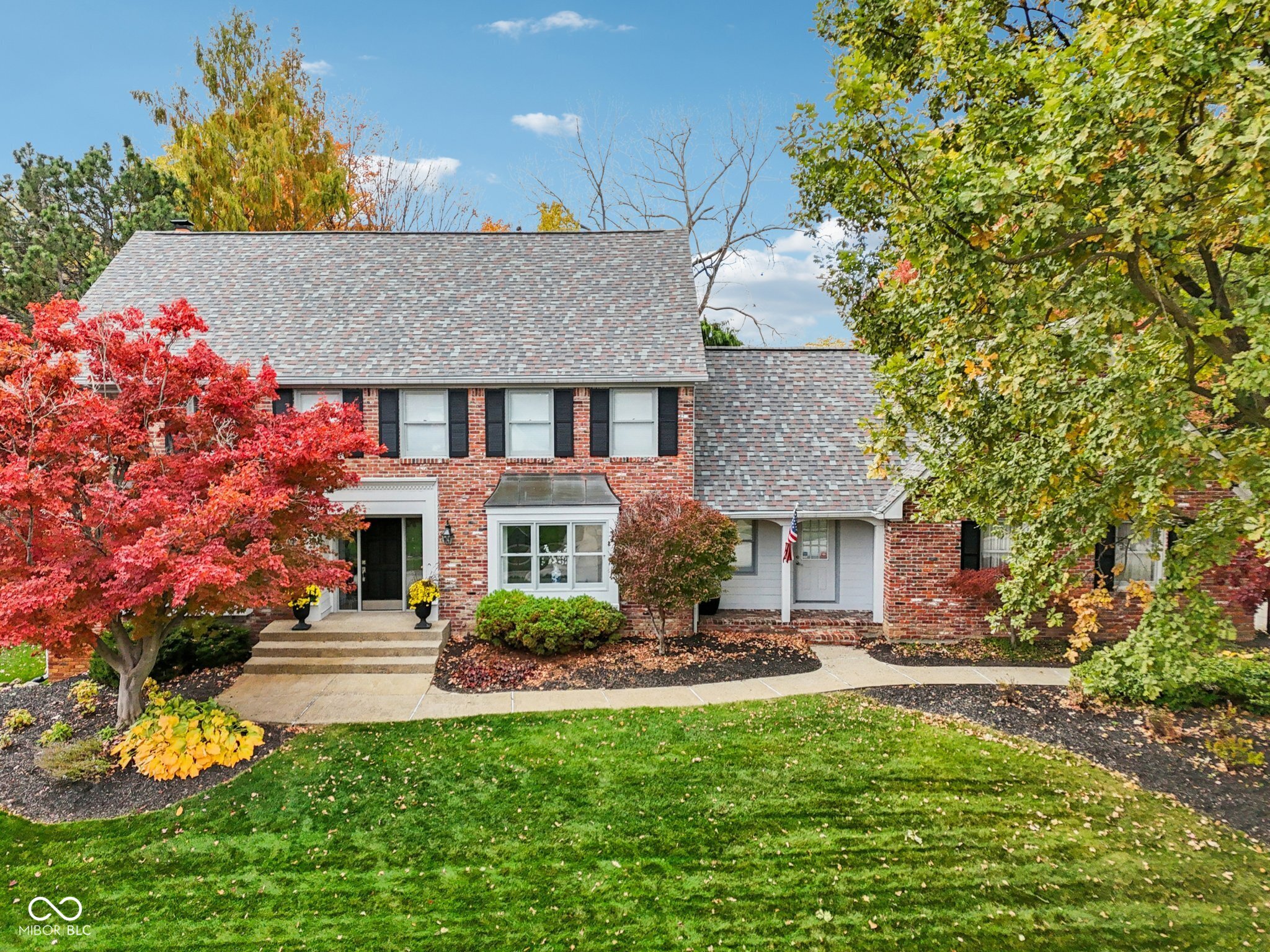 Nestled in a quiet tree-lined street in desirable Carmel, this stately red brick home offers a remarkable opportunity to embrace modern and comfortable living. Impeccably maintained with all the bells and whistles, this home is move-in ready. Enjoy the lovely living room with a view of the neighborhood, or cozy up to the fireplace in the great room beneath the soaring vaulted ceiling. Escape to the spacious sunroom, and enjoy the beaming natural light and lush backyard landscaping. The open floorplan on the main level allows for great flow, and provides ample space for everyday living, hosting, rest, and rejuvenation. The large updated kitchen with island, stone counters, built-in oven and microwave, and breakfast room has plenty of space for everyone, and is perfect for entertaining. The primary suite is flooded with light and boasts a huge en-suite with three vanities, two sinks, a heated towel bar, a large walk-in shower beneath a vaulted ceiling, and a separate W/C area. A massive walk-in closet completes the suite-thoughtfully designed with custom storage, abundant hanging space, and room to easily organize wardrobes for every season. Two more full bathrooms and two half bathrooms ensure convenience and ease for all. The thoughtfulness of this home-with its spacious closets, generous bathrooms, mudroom with utility sink, large main-level laundry, as well as a basement family room with built-ins-beckons you to settle in and enjoy. If all that wasn't enough, the outdoor living offers a low-maintenance Trex deck and sunken paver patio with a charming water feature. This exceptional space offers an ideal lifestyle for entertaining, relaxation, and experiencing the seasons.  Welcome home.