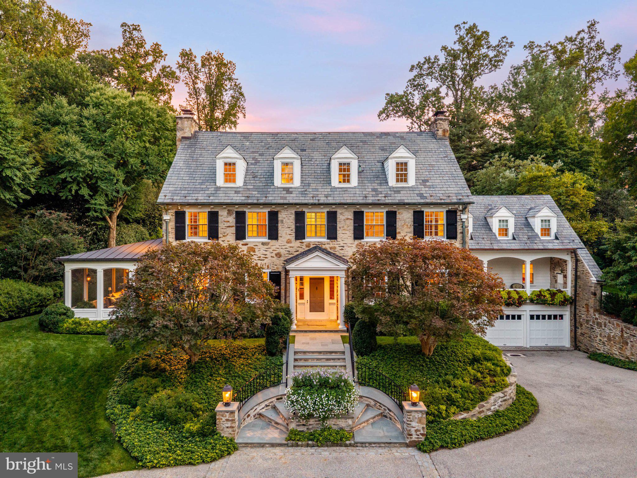 A North Haverford treasure. Welcome to 221 Rose Lane, a stately center-hall Colonial combining privacy, timeless architecture and walkability to Haverford town center and Merion Cricket Club. Rarely does a home of this caliber come to market—premier in location, beauty and condition, with extraordinary pride of ownership throughout.Twin curved flagstone stairways sweep around a raised central garden, creating a striking sense of arrival and setting the tone for the exquisite detailing throughout the home. Step into a wide center hall, where warm hardwood floors, gracious proportions and an elegant open staircase introduce timeless architecture and glorious natural light. Distinctive wallcoverings, custom millwork and thoughtful finishes lend warmth and individuality throughout.The gracious living room is anchored by a carved mantel and framed by deep window sills and French doors. Step outside to a dreamy large screened porch with heated stone floors—an idyllic place to listen to cicadas on early fall evenings or watch the game with the family. Also off the living room, arched doors introduce a striking study finished in emerald green. Custom built-ins frame an oversized window, while arched French doors open to the expansive Pennsylvania bluestone terrace and pristine gardens.A large dining room features a fireplace, exquisite millwork and windows on multiple exposures, with generous scale for entertaining. In the adjoining butler’s pantry, original cabinetry has been supplemented with custom glass-front cabinetry designed to match. Richly veined stone, a butler’s sink, wine refrigerator, beverage drawers, ice maker and dishwasher make the space as functional as it is beautiful.The kitchen pairs timeless white cabinetry with dramatic dark stone countertops and backsplash. A Sub-Zero refrigerator, abundant storage and an oversized center island with seating create a highly functional workspace. An inviting breakfast room is framed by French doors overlooking the manicured backyard. Across the room, another door opens to a covered front porch with exposed stone and a graceful arch—the perfect setting for morning coffee.The kitchen flows into a family room with a soaring barrel-vaulted ceiling and dramatic arched window. Custom built-ins, plantation shutters and multiple sets of French doors enhance its architectural character. Sunlight pours in, while terrace and garden access creates an effortless connection between indoors and out.The grand two-story staircase rises to the second floor, where double doors reveal a sumptuous primary suite. Two private bathrooms, a dressing room with fitted closets and an additional large walk-in closet create a luxurious retreat. An adjoining office with tall coffered ceilings, windows on three sides and a small wet bar offers a private place to work or unwind. Second-floor laundry completes this portion of the home. Farther down the hall, two beautifully appointed bedrooms occupy a private wing and share an updated bathroom, all executed with impeccable taste.A light-filled back staircase continues to the third floor, where three generously sized bedrooms share a hall bathroom, complemented by a cedar closet.Unparalleled stewardship at every turn. All casement windows have been replaced; the slate roof is in impeccable condition; and the composite shutters will never require repainting. The flagstone front steps were rebuilt with heating coils beneath, while the pristine rear terrace incorporates a sophisticated drainage system. The boiler, all air-conditioning units and water heater have been replaced within the past ten years.Mature perimeter trees provide privacy, and exquisite landscaping creates beauty at every turn. A private gate to Booth Lane enhances the home’s walkability to Haverford town center. An attached three-car garage provides everyday convenience. Commuters dream with easy access to major roadways and the sought-after Lower Merion School District.
