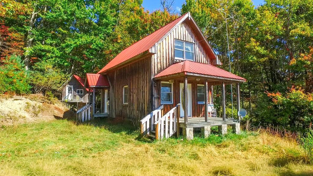 Discover the charm of this quaint 2-story contemporary mountain chalet tucked away on 1.39 ac +/- in the peaceful Southwest Mountains of Virginia. Offering 2BR/1.5BA, this retreat features an open kitchen and dining area, a cozy living room with a gas-log fireplace, and a covered front porch perfect for taking in the quiet surroundings.  The property includes a small unfinished guesthouse, ideal for future expansion.   Located in a prime outdoor recreation corridor, just minutes from Grayson Highlands State Park (wild ponies, hiking, Appalachian Trail access, and Mount Rogers—Virginia's highest peak), Whitetop Mountain, and the New River for fishing, paddling, and endless adventure.  A wonderful opportunity for nature lovers, hikers, and anyone seeking a true mountain lifestyle.  Home does need some TLC—cash buyers only should inquire.