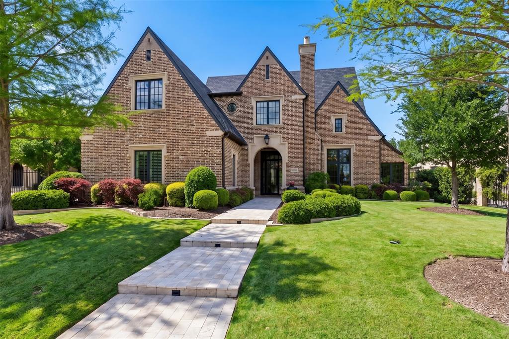 Located in the prestigious guard-gated community of Normandy Estates, this timeless Tudor estate offers nearly 6,000 square feet of refined living with a floor plan designed to function like a single-story home. Built in 2017, the residence features 4 bedrooms, 4 full baths, 1 half bath, and a thoughtfully designed layout ideal for both everyday living and entertaining.A private vestibule opens to a dramatic grand entry, where a sweeping spiral staircase and custom wine display create an unforgettable first impression. The expansive first floor spans approximately 4,699 square feet and includes the primary living spaces, study, media room, primary suite, and guest suite—all conveniently on one level.At the heart of the home, the chef’s kitchen opens seamlessly to the family room, where vaulted ceilings with exposed beams and walls of windows create a bright, inviting gathering space. A see-through fireplace connects the living area to the dining space and wet bar, creating a natural flow for entertaining, while the breakfast room is surrounded by windows overlooking the backyard.The private primary suite is a true retreat, complete with a sitting area, spa-inspired bath, dual walk-in closets, and separate water closets. A secondary guest suite with direct pool access is thoughtfully positioned for privacy and convenience.Upstairs, two additional bedrooms with en-suite baths are paired with a spacious game room, offering a private escape for guests or family. A large floored attic provides exceptional storage and future potential. Outdoor living is equally impressive, with a covered patio featuring a fireplace and Phantom screens, all overlooking a resort-style pool framed by mature landscaping for privacy and serenity.A rare opportunity to own a home that blends architectural character, everyday functionality, and exceptional entertaining spaces in one of Plano’s most sought-after communities.Open House Sunday, April 19 from 11:00 AM – 2:00 PM.