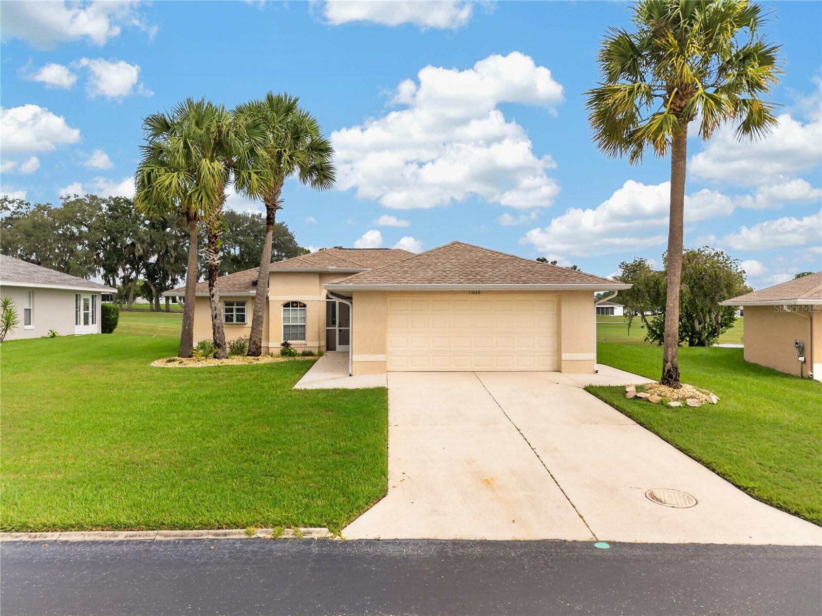 Virtually Staged. VIRTUALLY STAGED. GOLF COURSE VIEWS! Welcome to 11048 Moshi Lane in the guard-gated 55+ community of Tampa Bay Golf & Country Club! This beautifully maintained one-owner, 2-bedroom, 2-bath home with a 2-car garage sits on a premium homesite overlooking the greens of Hole #5, with peaceful pond views from the guest bedroom.Inside, you'll find a light, bright open floor plan with cathedral ceilings, fresh interior paint, luxury vinyl plank flooring, and beautiful architectural details. The updated kitchen features quartz countertops and newer stainless-steel appliances, while the spacious living areas open to a screened lanai where you can relax and enjoy the golf-course views.The primary suite offers gorgeous views, dual sinks, soaking tub, separate shower, and a generous walk-in closet. Additional highlights include a 2023 water heater, washer & dryer, and convenient garage side-entry door.Located in Deer Hollow Village, enjoy one of the community's lower HOA fees plus flexible lawn-care options.And the lifestyle? It's hard to beat! Enjoy 2 pools, golf, tennis, pickleball, fitness center, billiards, shuffleboard, card rooms, library, arts & exercise classes, onsite restaurant and pub/grille, entertainment, social activities and organized excursions.Conveniently located near Wesley Chapel, Tampa Premium Outlets, KRATE, Wiregrass, restaurants, medical facilities and major highways, with easy access to Tampa and beyond.Move-in ready, beautiful views, an incredible active-adult lifestyle—this is Florida living at its best!