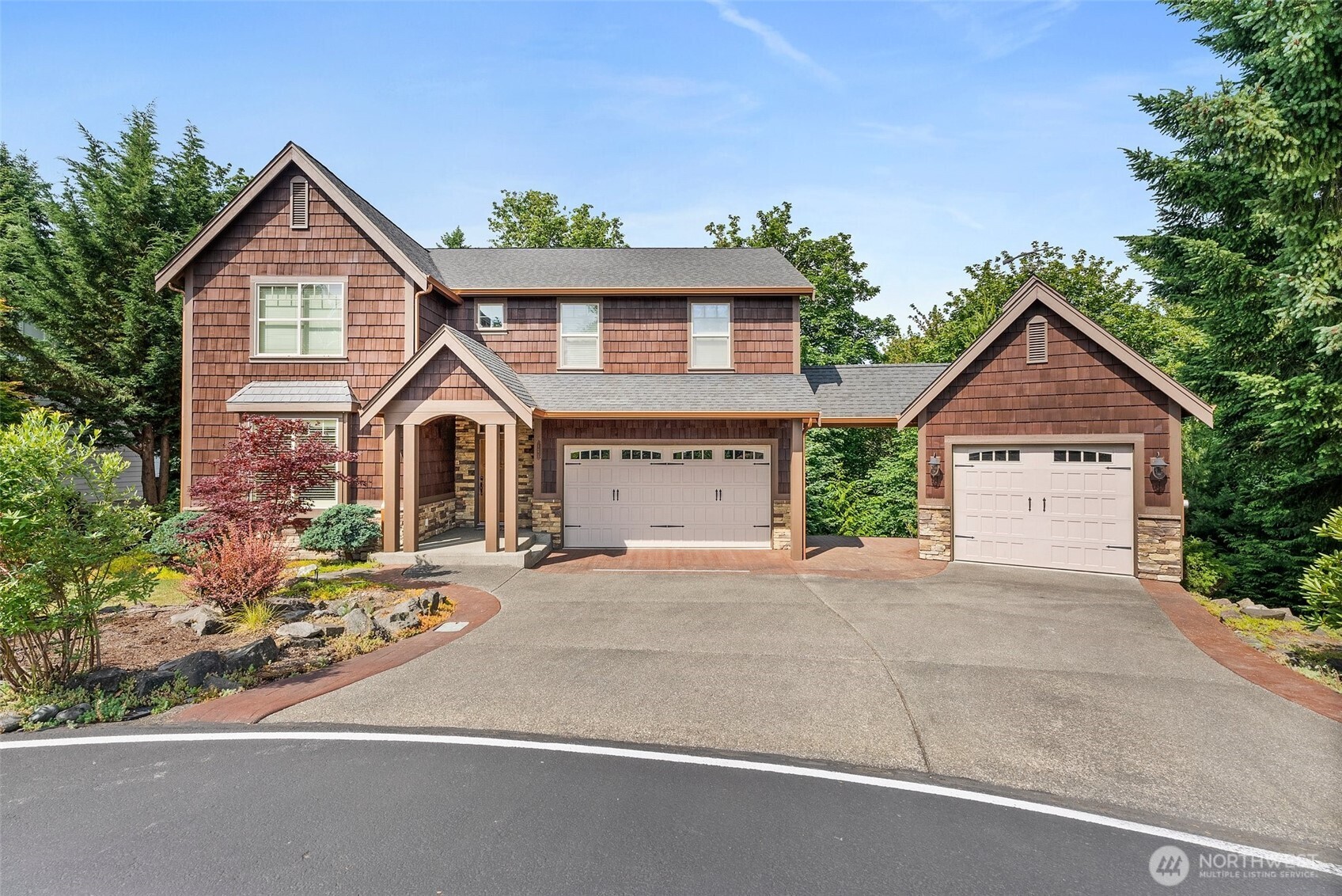 Tucked at the end of a serene cul-de-sac, this exceptional 4-bedroom, 3.25-bath home is a true retreat that blends timeless craftsmanship with modern comfort. Striking stonework flows throughout the home, creating warmth and character in every room. The luxurious primary suite is a sanctuary of its own, featuring exposed wood beams and elegant French doors that open to a peaceful escape. Entertain in style in the expansive rec room with a full bar, or take the party outside to the elevated kitchen balcony—perfect for al fresco dining or sunset views. The attached two-car garage is connected by a charming breezeway to a second garage, offering endless possibilities for a workshop, home gym, or extra storage.
