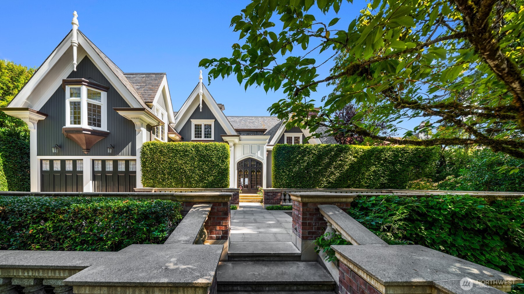 History and intention converge in this extraordinary Washington Park estate that stretches street to street, the product of masterful collaboration between renowned architects, artisans, and designers. In the tradition of the great English manors, the home was positioned to be arrived at, not simply seen, set behind a gated entry and rising above sweeping views of Lake Washington and the Cascades beyond. Mature gardens, established over decades, wrap the property in privacy rarely found this close to the city. The home has been crafted to serve both gracious entertaining and the rhythms of daily life with equal ease. The finishes speak to a standard of quality that is immediately and unmistakably felt: hand-waxed beams, extensive molding, and architectural antiques gathered from across centuries and continents. Room by room, each space unfolds and builds toward the next, rewarding those who take the time to linger. Every comfort assured and every detail considered. Nothing here is incidental. From the placement of a window to the curve of a stair rail, this residence offers a way of living that feels unique yet comfortable. Each room finely tuned during a dedicated three-and-a-half-year transformation. A quiet, tree-lined enclave nestled between Lake Washington and the lush Arboretum, Washington Park offers a peerless balance of private retreat and urban accessibility. This is a residence of rare distinction awaiting its next stewards.