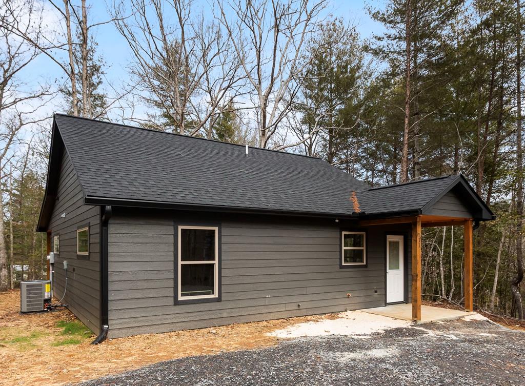 A new product by one of Murphy's best home builders! This charming single-level 2 bed/2 bath home offers a serene retreat just minutes from town. This home is BRAND NEW, promising a delightful blend of rural ambiance and modern amenities. The exterior boasts a rustic presence, featuring rough-cut siding that compliments the natural surroundings. The fully covered view porch is the perfect spot to relax and take in nature's sights and sounds. Inside you'll be greeted with a warm interior and an inviting and cozy atmosphere. The heart of this home is the Great Room, where a stunning stacked stone corner fireplace provides both warmth and a focal point for gatherings. The vaulted wood ceiling enhances the sense of space and airiness in this room, making it an ideal place to entertain or unwind. Hardwood flooring extends throughout the home, adding a touch of timeless beauty. The kitchen showcases hickory cabinets, granite countertops, and stainless steel appliances. Come be the very first to call this brand new cabin HOME!