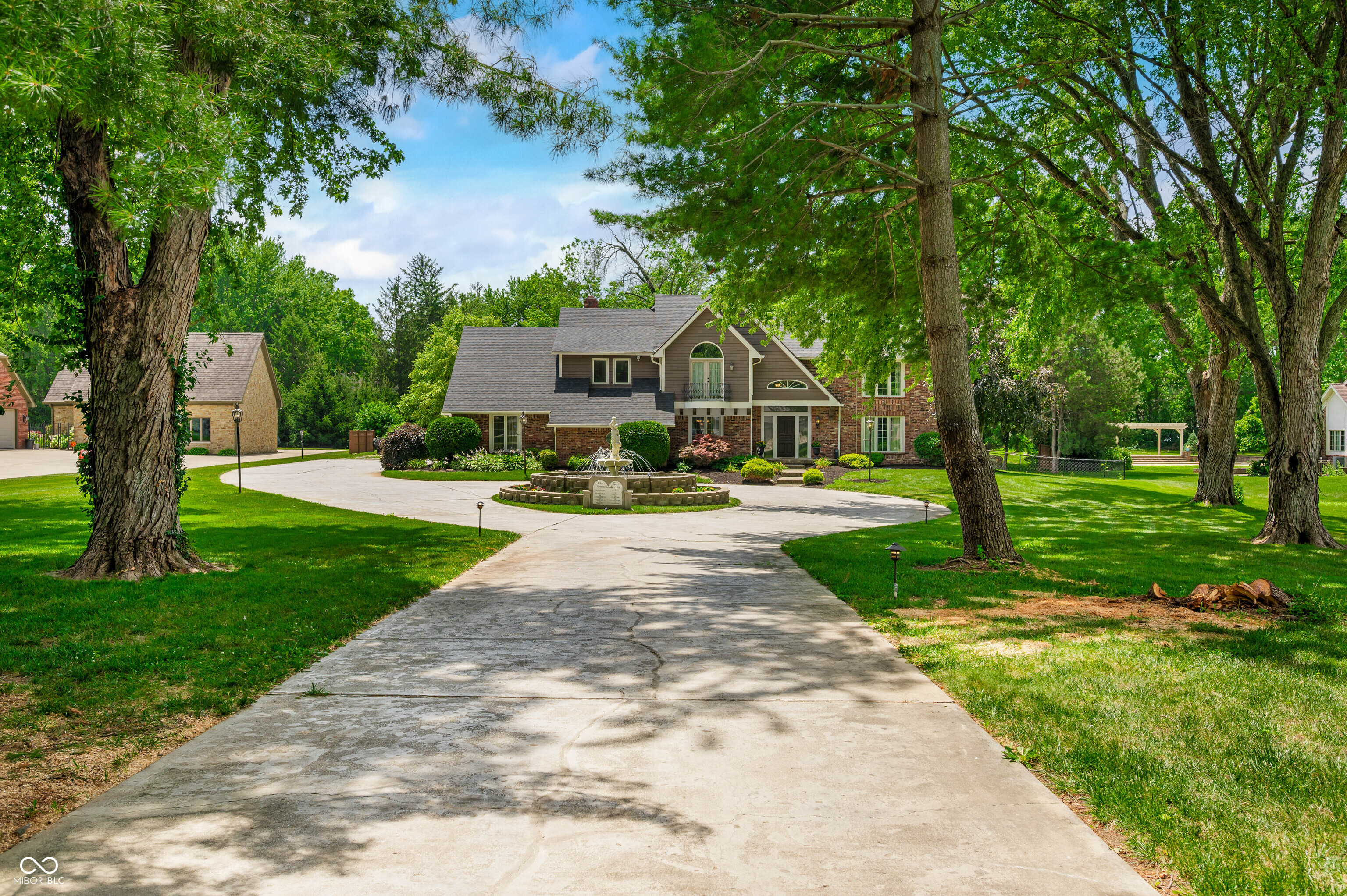 Welcome to a rare blend of timeless architecture and everyday comfort-nestled on 1.7 private, park-like acres just minutes from downtown Indianapolis. This exceptional estate invites you to live beautifully, offering 5,978 sq ft of thoughtfully designed space for connection, relaxation, and unforgettable gatherings.    From the moment you step inside, the grand spiral staircase and custom details speak to the home's elegance and character. With 4 spacious bedrooms, 4 full baths, and 2 half baths, every corner of this home is crafted for comfort. The primary suite is your personal retreat, featuring a spa-like bath with oversized soaking tub, dual vanities, walk-in closet, and a bonus room ideal for a fitness studio, home office, or quiet lounge.    The heart of the home is the gourmet kitchen-perfect for everyday moments and festive entertaining. Natural light pours into the living spaces through oversized windows, framing serene views of the grounds and inviting in the beauty of every season.    The finished basement offers flexible space to gather, relax, or create your dream media or game room. Step outside into your private backyard oasis: an in-ground heated pool, built-in grill, gazebo, and multiple gathering areas ready for laughter and memory-making.    At the back of the property, a charming guest house with an oversized 33x18 garage provides space for visitors, workshop needs, or RV storage. Surrounded by mature trees and thoughtfully landscaped grounds, this property offers the feeling of a peaceful retreat-just minutes from the city's best dining, shopping, and entertainment.    Complete with a whole-house generator and smart layout, this home blends beauty, function, and security. It's more than a home-it's a lifestyle, a legacy, and your next chapter.