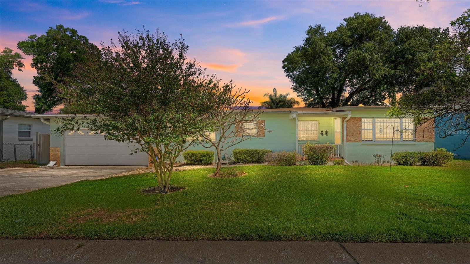This well-maintained mid-century ranch has been owned by a single family since it was built and is now ready for its next chapter. Prior to listing, the sellers commissioned a full home inspection — available upon request — so buyers can move forward with confidence knowing any remaining updates are purely cosmetic.Inside, original hardwood floors run through the main living areas, and the open layout connects a spacious living room to a formal dining area with accordion room dividers, offering flexible use of the space. The kitchen features ample cabinet storage and a pass-through window to the adjacent dining room. The primary bedroom includes an en-suite bath, while two additional bedrooms share a second full bath.The in-law suite adds meaningful versatility — whether used for extended family, a home office, or additional living space. Out back, a screened pool enclosure with a private pool anchors the fenced yard, with a paver patio and low-maintenance rock landscaping surrounding it.The attached two-car garage, wide concrete driveway, and mature tree canopy round out a property that has genuine bones and needs only a personal touch to truly shine.
