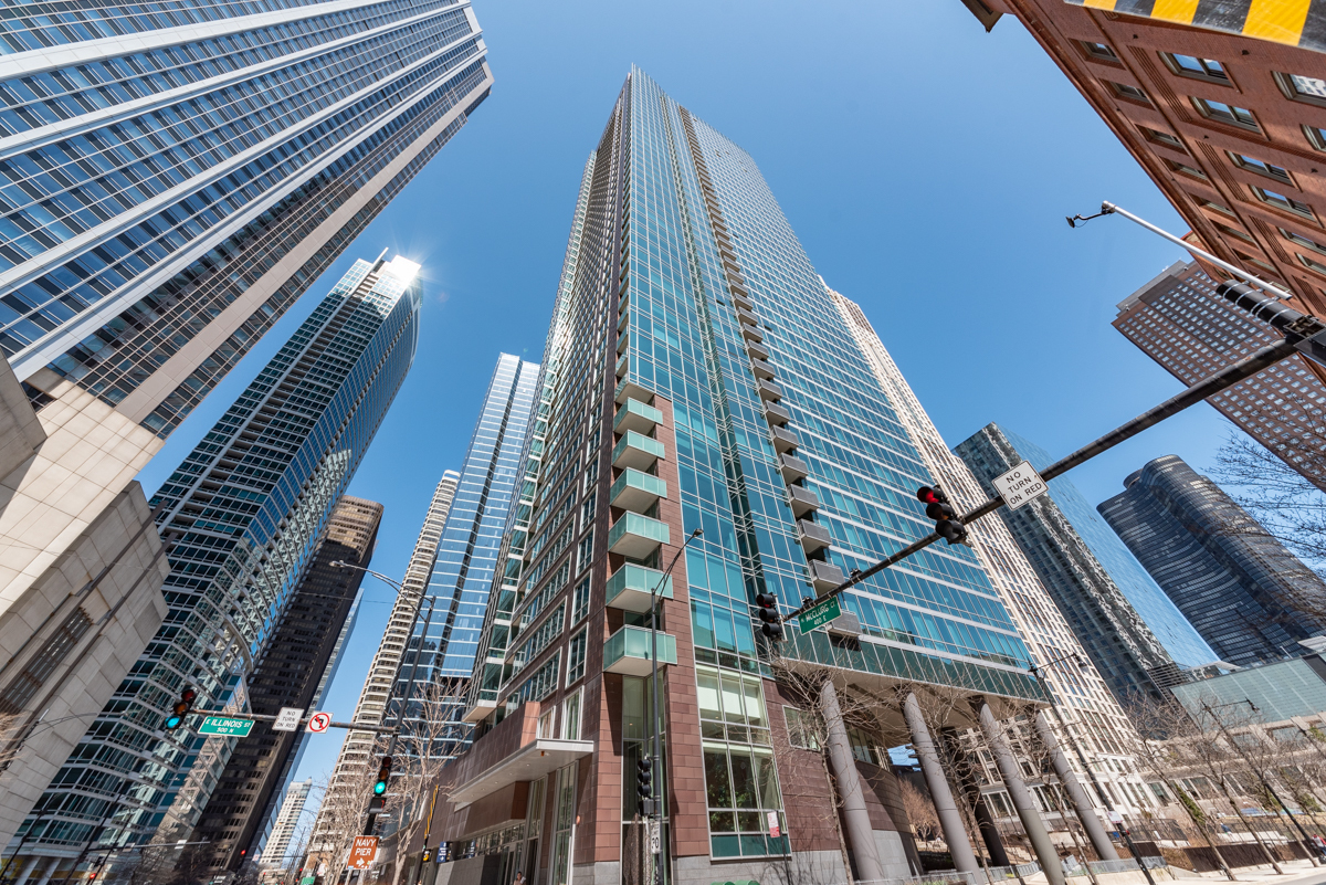 Experience elevated urban living in this stunning southeast-facing corner unit, perfectly situated in the heart of Streeterville. This expansive 3-bedroom, 2.1-bath residence features floor-to-ceiling windows that flood the space with natural light and offer panoramic views of the city skyline, Chicago River, and Lake Michigan. Beautiful hardwood floors run throughout, including all three bedrooms, enhancing the home's warm and sophisticated appeal. The open-concept layout boasts a spacious great room equipped with motorized roller shades and plenty of room for both living and dining. Step out onto your private east-facing balcony for a serene view overlooking Bennett Park. The chef's kitchen is designed for both style and functionality, featuring rich dark wood cabinetry with under-cabinet lighting, granite countertops, tile backsplash, stainless steel appliances, a gooseneck faucet, pantry, and a convenient breakfast bar that opens into the living space-perfect for entertaining. Retreat to the generous primary suite, complete with a fully customized walk-in closet outfitted with Elfa shelving and an elegant en suite bath featuring a double vanity, walk-in shower, and separate soaking tub. The thoughtful split floor plan places the two additional bedrooms on the opposite side of the unit for added privacy. The second bedroom includes custom built-ins, three closets-including a walk-in-and its own en suite bath. The third bedroom is equally spacious with ample closet space. Additional features include a stylish powder room for guests, in-unit washer/dryer, central heating and cooling, and a dedicated storage cage. This full-amenity elevator building offers 24-hour door staff, a fitness center, outdoor pool, residents' lounge, bike storage, and more. Located directly on 1.5-acre Bennett Park-which includes a dog park-you're just steps from Target, Whole Foods, Lake Michigan, Navy Pier, Ohio Street Beach, the Lakefront Trail, Magnificent Mile, and countless dining, entertainment, and shopping options, including a movie theater and two bowling alleys. Don't miss the opportunity to live in one of Streeterville's most sought-after locations. One premium deeded parking spot in a heated garage available for an additional $50,000.
