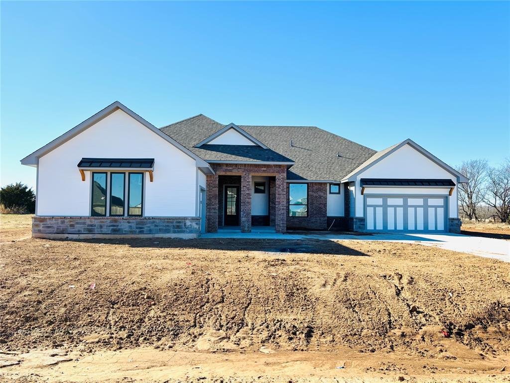A Truly Stunning Floor Plan That Captures Timeless Elegance and Modern Design! From the moment you pull up, this home is sure to impress with its striking curb appeal and beautifully designed layout. Step through the front door and be welcomed by a wide, inviting hallway that leads into a massive living room. The centerpiece of this space is a gorgeous fireplace, tastefully accented by built-in shelving on either side, creating a warm yet sophisticated ambiance. The main areas of this home feature wood tile flooring, adding durability and style. The kitchen is a masterpiece of design and function, showcasing custom cabinetry reaching all the way to the ceiling, thick quartz countertops, under cabinet lighting, and floating wood shelving. A large decorative vented wood hood, premium stainless steel built-in appliances, and a spacious island make this kitchen as functional as it is beautiful. The oversized pantry offers ample storage to keep everything organized and within reach. The 12-foot glass sliding doors in the living room telescope open to reveal a sprawling covered patio, perfect for outdoor gatherings, relaxation, or enjoying the peaceful surroundings. The primary suite is your personal oasis, offering an enchanting loggia that connects the luxurious primary bathroom to a private study or retreat space. The primary bathroom features a freestanding soaking tub, a spacious walk-in tiled shower, a two-sink vanity, an enclosed water closet, and abundant storage. The expansive walk-in closet with a window is both practical and elegant. Every detail in this home has been meticulously crafted to combine beauty and functionality. Situated in a tranquil neighborhood with an outbuilding-friendly HOA, this property offers the perfect blend of peaceful living and thoughtful design. Don’t miss the chance to make this extraordinary home your own—schedule your private showing today!