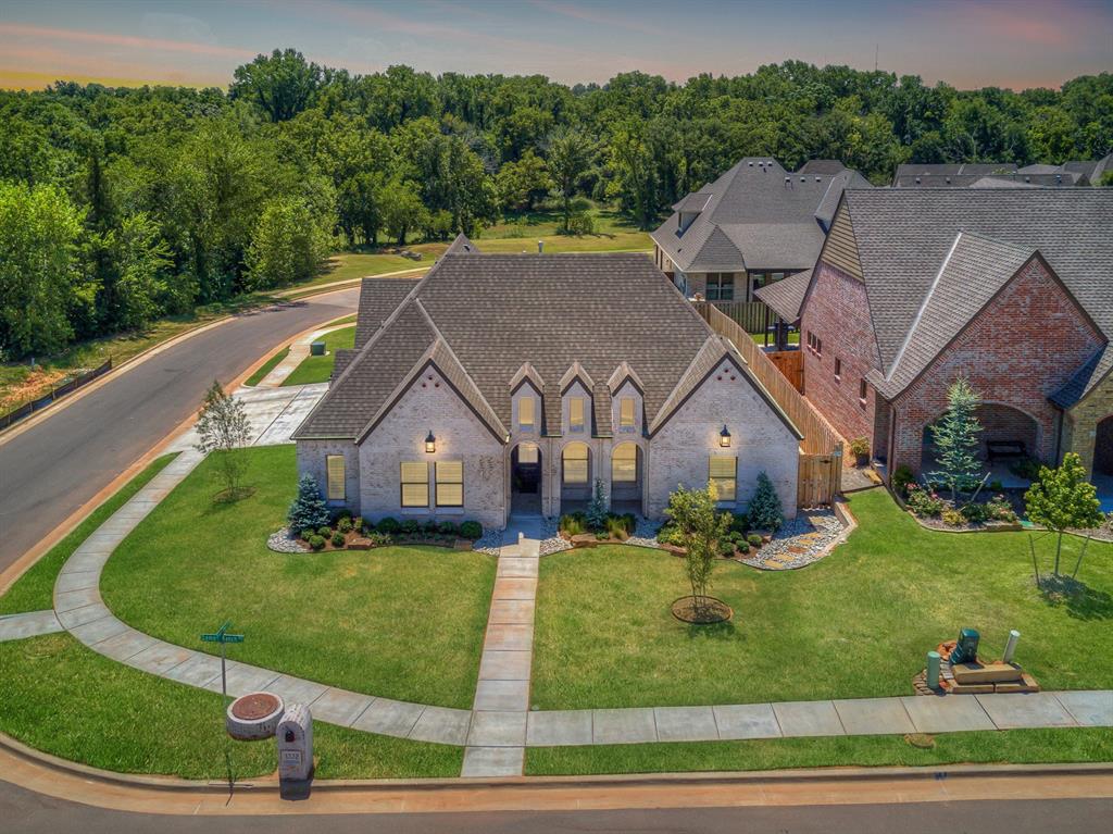 Superior quality and exceptional workmanship define this luxurious home, crafted for those who expect only the very best at 1332 Lemon Ranch Road, in Edmond, Oklahoma. A true residence of distinction, it showcases premier amenities, thoughtful design, and meticulous attention to every detail. Tucked within the sought-after Edmond community of Birnam Woods, this property is a genuine showstopper from the moment you arrive. Enter through the foyer and immediately appreciate the refined finishes and elegant architectural elements that set this home apart. The spacious, open-concept living area features a dramatic vaulted ceiling, abundant natural light, and seamless flow for both everyday living and entertaining. A wall of double French doors leads to the inviting outdoor living space, expanding the home’s entertainment potential. The contemporary kitchen is a perfect blend of style and function, offering generous cabinet and counter space, a massive center island, and high-end appliances including 5-burner gas range, built-in oven, and a refrigerator that stays. Its modern design creates a space that feels both cutting-edge and welcoming. The primary retreat serves as a private sanctuary, complete with a double vanity, relaxing jetted tub, and beautifully tiled walk-in shower. The flexible floor plan continues upstairs, where you’ll find a secondary bedroom, full bathroom, & an impressive game room or studio-style apartment equipped with a kitchenette and its own private entry from the garage, ideal for guests, college-age family members, or multi-generational living.  Fourth bedroom on the main level makes an excellent study or home office. Additional features include plantation shutters, spacious storage, & an outdoor living area perfect for grilling, gatherings, or quiet evenings at home. This remarkable property combines luxury, comfort, & versatility in one stunning package, an exceptional opportunity in one of Edmond’s most desirable neighborhoods. Welcome Home!