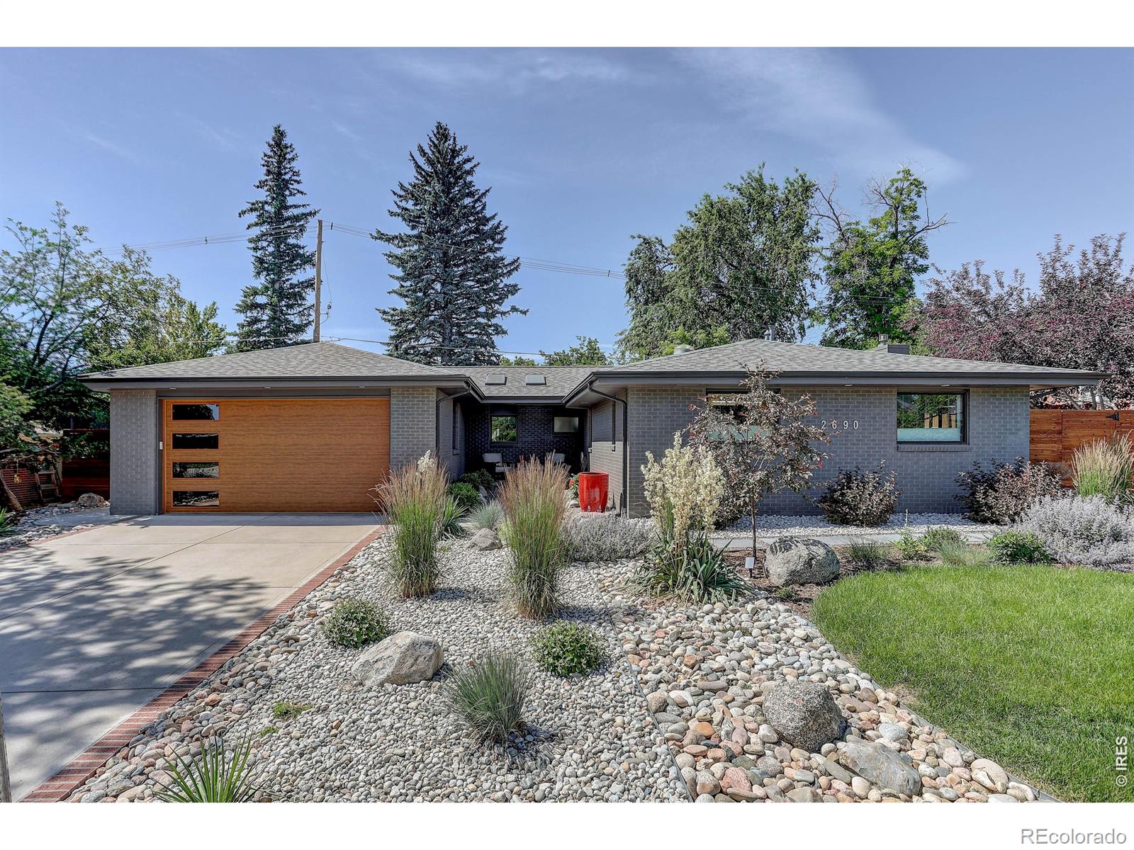 Perfectly located just one block from the University of Colorado and moments from the Boulder Bike Path, this meticulously maintained and beautifully updated brick ranch offers convenient single-level living in one of Boulder's most desirable neighborhoods. Inside, you'll find four bedrooms, gorgeous hardwood floors, vaulted ceilings, a cozy gas fireplace, an office nook, and a well appointed kitchen featuring granite countertops and stainless steel appliances. The oversized two-car garage provides plenty of room for vehicles and storage. Step outside to a private , fully fenced backyard designed for entertaining and relaxation, complete with two patio areas and a rooftop deck showcasing mountain views, accessed by a custom metal spiral staircase. One of the bedrooms is ideally suited for a guest suite, mother-in-law quarters, or potential short term rental, featuring its own private entrance and en-suite bath for added flexibility.
