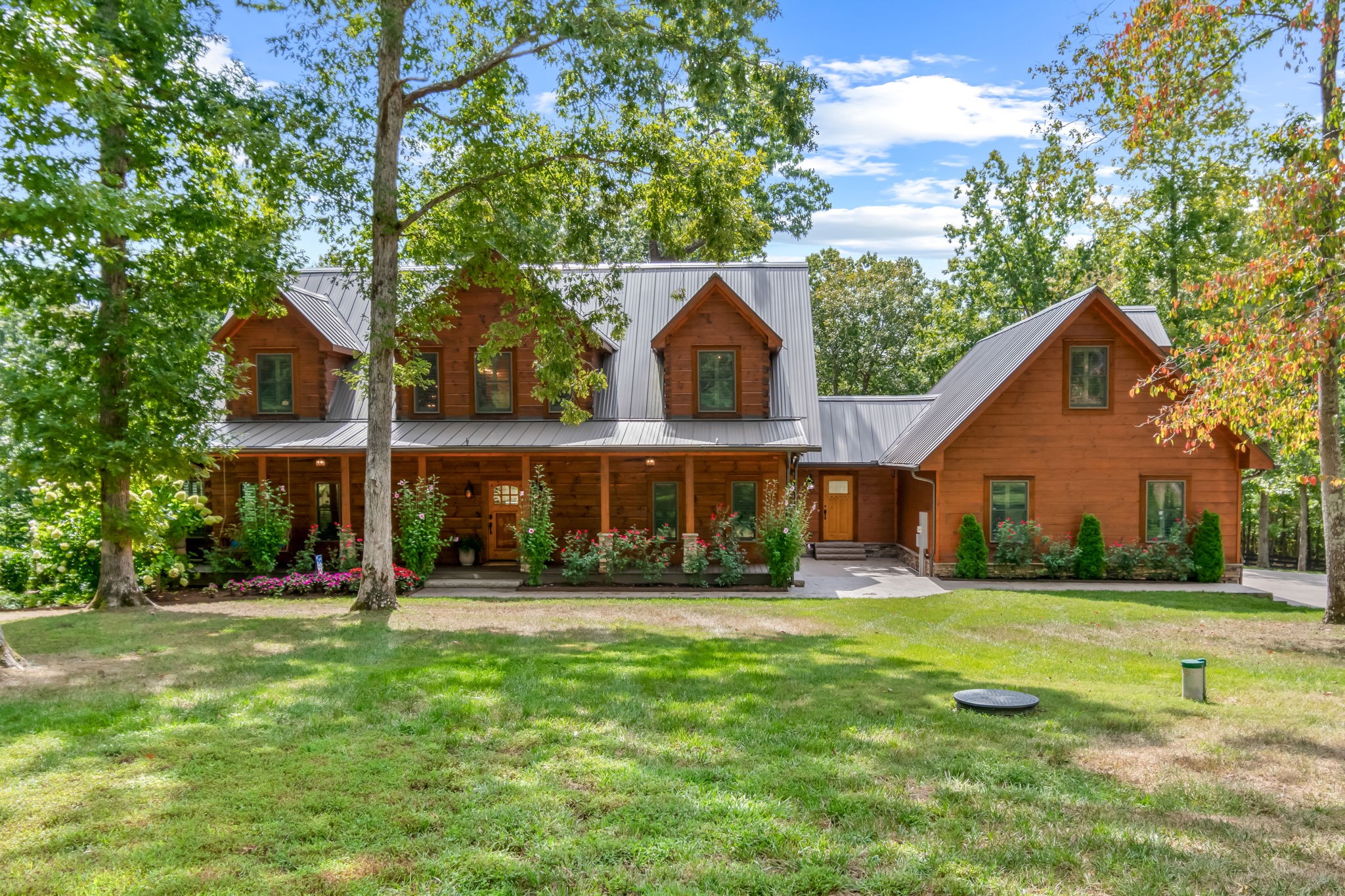 Modern Luxury Meets Log Cabin Charm w/ additional build site – Just 10 Minutes from the Leiper's Fork Village and Natchez Trace Parkway!
Welcome to your private wooded paradise: a stunning 5BR/4.5BA custom log home on 78 acres of pure Tennessee magic. Sophisticated modern finishes blend effortlessly with timeless rustic charm in a warm, flowing layout featuring two luxe guest suites, a dreamy primary retreat, and a versatile studio space above the garage—perfect for music, art, or working from home.
Step outside and the story truly unfolds: sip morning coffee on the deep, shaded front porch as the sun rises through the trees. Gather friends for sunset cocktails on the expansive back deck, or share stories by the crackling outdoor fireplace on crisp autumn evenings. A serene freshwater pond glistens nearby, while a creek winds gently through the woods—complete with platform decking for picnics, meditation, or camping with the kids. There's even a charming chicken coop for fresh eggs and a touch of farmhouse fun. A neighboring 5-bedroom build site offers potential for expansion, guest quarters, or multigenerational living. This site includes septic approval and existing well. Private, peaceful, and just 10 minutes from the vibrant charm of Leiper’s Fork Village, this property is more than a home—it’s a lifestyle! 
Additional property features include: Encapsulated and condition crawlspace, 1800 gallon in ground water tank, water softener and filtration, conditioned 3-car garage, irrigation system for lawn and landscaping, whole house humidifier, and retractable motorized deck screens off primary. Eligible to continue greenbelt status.