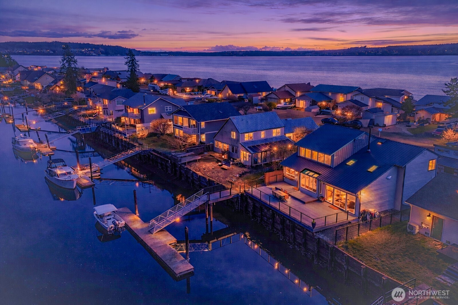 Completely remodeled & designed to highlight the waterfront lifestyle. From the moment you step inside you’re welcomed by vaulted ceilings, exposed beams, skylights, fresh interior paint, new trim, new Pergo flooring & new carpet. The sunken living room creates an inviting space centered around a wood stove & built in entertainment center. The fully refreshed kitchen blends style & function w/refaced cabinets, Corian counters, SS appliances, a gas Wolf range, convection oven, built in ice maker, butcher block eating area & 3 pantries. Just off the kitchen, the solarium is flooded w/light & offers a seamless connection to the outdoors. On the main level you will find a spacious bedroom. As you head upstairs the primary bedroom allows for easy living, the remodeled bath features double sinks, a tile surround shower & a freestanding tub. Upstairs the large open loft w/a modern metal banister adds flexible space. Nearly every major component has been updated, including new windows, insulation in the walls & attic, metal roof, gutters, light fixtures & more. Step out the slider onto the brand new Trex deck, w/a glass railing & built-in lighting, then follow the walkway down to your dock & ramp (just 5 yrs old) to enjoy boating, fishing or crabbing. Addt'l features include~ peek-a-boo view of Mt. Baker, Generac auto generator, RV parking, 12x16 shed, new fence, 42” entry door & a commercial freezer. Located in the Bridgehaven community w/a private marina & clubhouse.