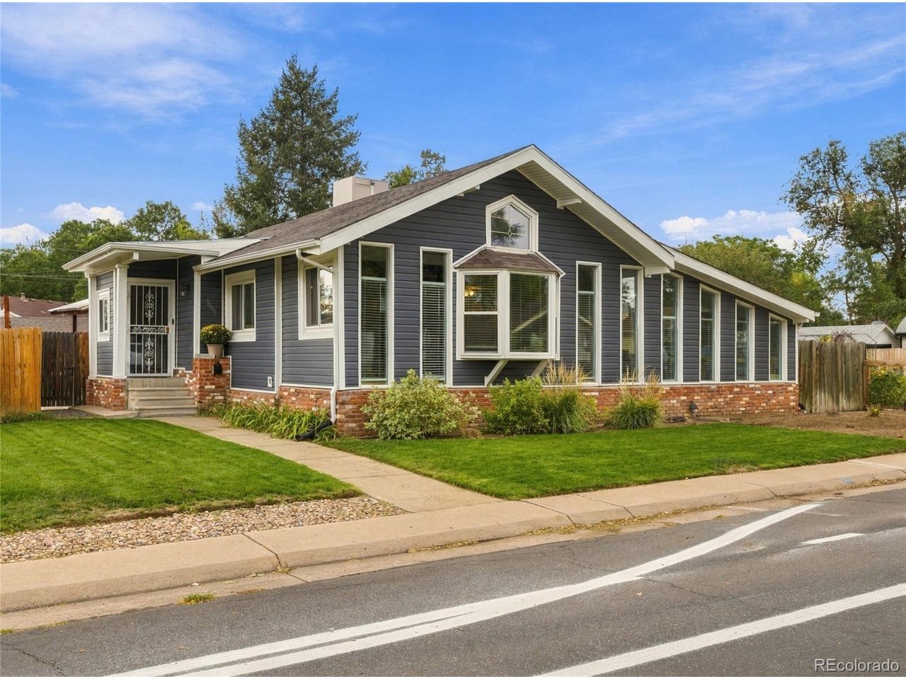 A beautifully updated home on an exceptionally large corner lot, this Englewood property offers something increasingly hard to find-great indoor spaces paired with a backyard you'll truly want to use.Inside, the bright and inviting main level features three bedrooms and two bathrooms, including a primary bedroom with its own private bath. The spacious living room is filled with natural light from an abundance of windows, while a charming bay window (new in 2020!) with built-in bench seating creates the perfect spot to relax. The updated kitchen offers plenty of workspace, an adjoining eating area, and convenient access to the covered back deck for easy indoor-outdoor living.The partially finished basement adds valuable flexibility with a non-conforming 4th bedroom plus a separate bonus/play room-ideal for guests, hobbies, a home office, workout space, or additional living area.It's the backyard that makes this home truly stand out. The oversized corner lot provides an impressive amount of outdoor space, with a large grassy yard, comfortable sitting area, covered deck, and even a private half-court basketball court. Whether you're hosting a summer barbecue, shooting hoops, gardening, or simply enjoying a Colorado evening outside, there is room here to make the backyard your own.Lifetime transferable warranty on the newer siding adds great peace of mind. A detached garage provides additional parking and storage, and the home is conveniently located just a block from Englewood High School, walking distance of dozens of restaurants and just a few blocks from the walking trails in Cherry Hills Village. Nicely remodeled, full of natural light, and situated on a lot that is difficult to duplicate, this home delivers character, functionality, and exceptional outdoor living in the heart of Englewood.