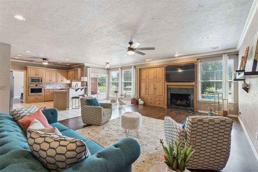 3.75% VA Assumable Loan offered! Experience luxury and space in the gated Deer Creek Hills neighborhood! Perfectly positioned on a generous .71 acre lot, this elegant estate offers peaceful rural living just minutes from the city. From the moment you arrive, you'll be captivated by the curb appeal, lush shrubs, and fresh mulch framed by classic red brick exterior. Step through French doors into a foyer, and you'll immediately notice the warm, inviting atmosphere. To the left, you'll find a spacious formal living area and a refined dining room, both adorned with rich hardwood floors. Just beyond, the home opens up to a stunning open-concept kitchen, dining & living room flooded with natural light from expansive windows. The living area features custom woodwork framing a wood-burning fireplace, while the kitchen shines with granite countertops, plenty of cabinetry, built-in 5-burner gas cooktop, all-new stainless steel appliances (2018), black hardware, and crown molding. Updated lighting and hardwood floors run seamlessly throughout the main living spaces. The primary suite is a retreat with private patio access, views of the pool, and an ensuite bath that boasts a jetted tub, double vanities, stall shower with obscure glass doors, and a walk-in closet. Three additional bedrooms all offer spacious walk-in closets, large windows with blinds, and share two beautifully maintained bathrooms, one with a dual-sink vanity, the other with plenty of counter space and both featuring tub/shower combos. A well-equipped laundry room includes ample counter space, cabinets & a sink. Step outside to your private oasis, complete with a modern built-in pool & diving board, oversized covered patio, and plenty of open space for entertaining. The new wood privacy fence, in-ground storm shelter, and large trees offer both comfort and peace of mind. Additional upgrades include both HVAC systems and ductwork replaced in 2016, each equipped with air purifiers for improved indoor air quality.
