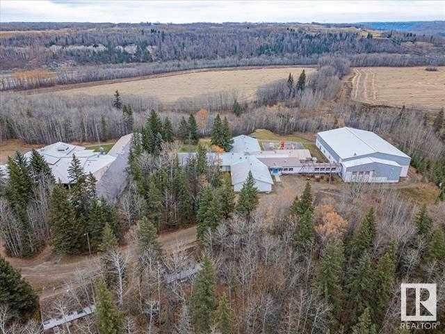 Former Education Facility located right along the North Saskatchewan River. Full School with Classrooms, Dorm Rooms, Industrial Kitchen, Laundry Facility, Office space, Beautiful Full sized Gymnasium with bleachers and more. Metal cladded maintenance shop with two bays with cement floor, heat, power, and office space. There is a log home that is currently rented out. Outbuildings, Playground, a large pavement pad, and an old church are a few other highlights of this unique property. This 124.79 acre property is tucked away, secluded with trees, and would be perfect for a Rehabilitation facility but has many other options as well! This Gorgeous River property has to be viewed in person to appreciate everything it holds, including the location!