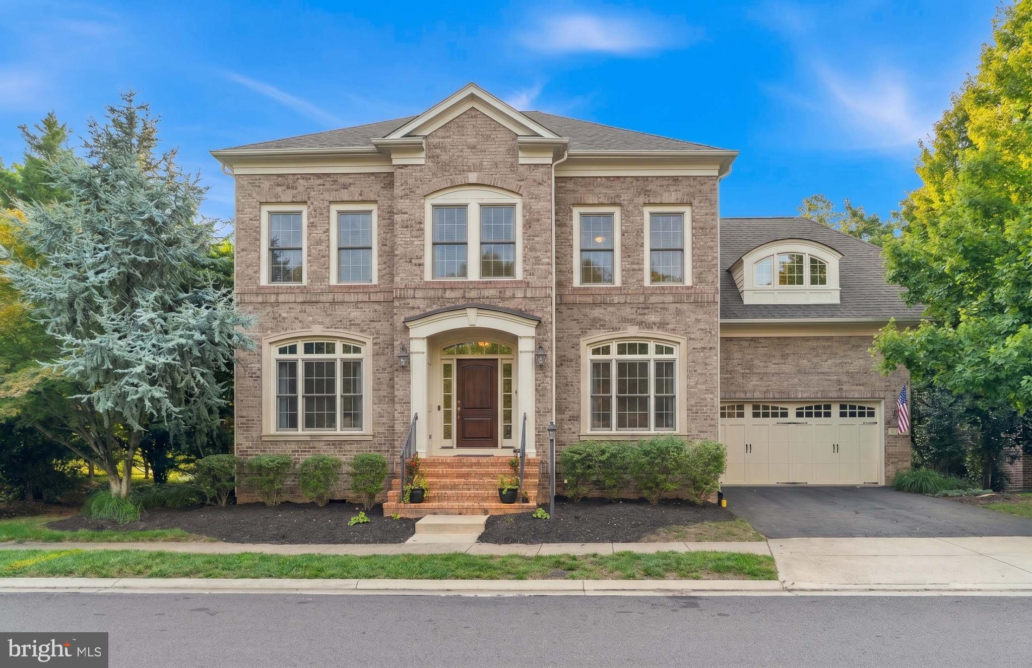 Welcome to 23053 Olympia Drive, an exceptional 5-bedroom, 5.5-bathroom residence offering over 5,000 square feet of luxurious living. As one of Gulick's former model homes, this move-in ready property showcases timeless craftsmanship, upscale finishes, and thoughtfully designed living spaces. Perfectly positioned on a private lot backing to peaceful woodlands, this stunning home blends elegant living with exceptional entertaining spaces.Rich hardwood floors flow throughout the main level, where a grand spiral staircase makes an unforgettable first impression. Elegant columns beautifully define the formal living and dining rooms while maintaining an open, sophisticated feel. At the heart of the home is the chef-inspired gourmet kitchen, featuring an oversized center island, Sub-Zero and JennAir appliances, custom cabinetry with a paneled refrigerator that seamlessly blends into the cabinetry, a convenient butler's pantry, and abundant prep space. The sun-filled breakfast area opens to an expansive deck, where you'll enjoy picturesque views overlooking the serene wooded backdrop.The adjoining family room offers an inviting gathering space centered around one of the home's four fireplaces, while the private main-level office is complete with custom floor-to-ceiling wood built-ins, creating the perfect study or work-from-home space. And a mudroom that provides seamless access to the three-car garage.Head up the spiral staircase to the upper level, where a loft provides the perfect flex space for a secondary family room, playroom, or reading lounge. The luxurious primary suite serves as a true retreat with its own sitting room featuring a fireplace, private balcony overlooking the wooded backdrop, two oversized walk-in closets, and a beautifully renovated spa bath with heated floors, dual vanities, a soaking tub, and a spacious walk-in shower. Three additional bedrooms each feature their own en-suite bathroom, and the laundry room is conveniently located on the upper level.The finished walkout lower level is designed for entertaining, featuring a custom wet bar, spacious recreation and lounge areas, a dedicated theater room with surround sound, and a fifth bedroom with its own en-suite bathroom—ideal for guests, multigenerational living, an au pair suite or gym.Step outside to your private backyard oasis, complete with extensive hardscaping, a built-in gas and wood-burning fireplace, a large storage shed, and plenty of room to add a future in-ground pool.Located in the highly sought-after Brambleton community, residents enjoy exceptional amenities, including five outdoor pools, tennis and pickleball courts, basketball and volleyball courts, miles of scenic walking trails, playgrounds, parks, and Brambleton Town Center's restaurants, shopping, entertainment, and movie theater. Conveniently located near Route 50, the Dulles Greenway, Dulles International Airport, Tysons, and Washington, D.C., this extraordinary home offers the perfect combination of luxury, lifestyle, and convenience.