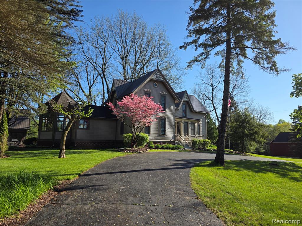 This is an exquisite 1875 historical home known as a Folk Victorian is hard to find! Remarkable restoration retained authentic beauty in keeping the elaborate interior & exterior decor and appointments, an unusual find in a world of copy cat construction. The original 80 acres was owned by the Empey family in the late 1800's & this treasure remains on 20 of the original Metamora Hunt acres, where the occasional rider or carriage still trot down the roads. Mature trees, a beautiful 1 acre pond w/gazebo and 15 acres of woods for hunting or hiking enhance this site. A circle driveway brings you to the entrance with a leaded glass front door, opening to the Parlor w/high ceilings, tall moldings & floor trim, large bedroom, full bath, study or nursery and laundry room. An historic Hunt-themed hearth room w/pegged floors and full brick wall fireplace is delightful, and flanks a large family room w/access to the deck and hot tub. New custom kitchen w/granite island & counters leads to dining in an eye catching Octagon room w/vaulted ceiling and walls of windows. The 2nd floor offers 2 bedrooms and a primary suite with sitting area, huge walk in closet, lovely new bath and attic access for storage. A very cool & dry Michigan basement has exceptional storage, workshop, wine cellar, furnace & brand new hot water heater. Carriage-style 3 car garage w/loft to finish and 2 historical barns w/water, electric & charming appeal. Metal roof, whole house attic & ceiling fans & beautifully maintained for its new owners to make memories.  In Metamora, all year activities include Music in the Park, Country Days & Hot Air Balloon Festival, Halloween Candy Drop, theater & book signings at the Historical Society, a Library & wonderful meals on the patio or special holidays at the White Horse Inn. Visit the General Store for wine tastings, shopping, lunch or coffee & experience the parades and equine events hosted by the community and the occasional horse drawn carriage! Home Warranty.