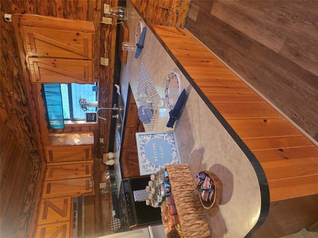 This Beautiful 1020 Sq ft, 2 Bed 1 and 1/2 Bath, detached one car garage/building (it has a slab floor,however the walls are not sheet rocked), and a one car car port on two Lots 19 & 20. It is nestled just off of highway 9 in the Little Axe area, really close to being right in between Shawnee and downtown Norman. It sits just behind Harps grocery store off of highway 9. It is less then 5 miles to the hiking and biking trails at Lake Thunderbird. The Location is outstanding! It sits on 2.52 acres filled with beautiful trees and wildlife. While I was there taking photos I scared the deer and the deer scared me. It was really cool. This home is a true log cabin and would be a great starter home for anyone or a great place to size down and retire too. By what I can see it seems very solid and like it has been loved and cared for. It has solid wood cathedral cealings and wood floors with log walls and solid wood cabits. Several built ins even a built in murphy bed in the 2nd bedroom. The half bath is locataed toward to front potion of the hall and located in it is the washer and dryer area. The full bath is located in the main bedroom and has a shower tub in it. It has a Trek Deck they use a hidden fastening system to fasten them down and are known for their 25 year no maintence pitch. It has a new septic owner owned, propaine tank also owner owned (meaning they come with house they are paid for not leased. It has well water, however the well is a part of the Wildfire addition You pay a 50.00 a month $600.00 annual fee to HOA for maintence on the well and maitenence on the roads. However you do not have a water bill and you still have the perks of getting well water. This land is gorgeous, it has several good size cleared out areas, but also lots of trees and wooded spots. Its just a really great little spot if you enjoy country living, outdoors, wildlife etc.