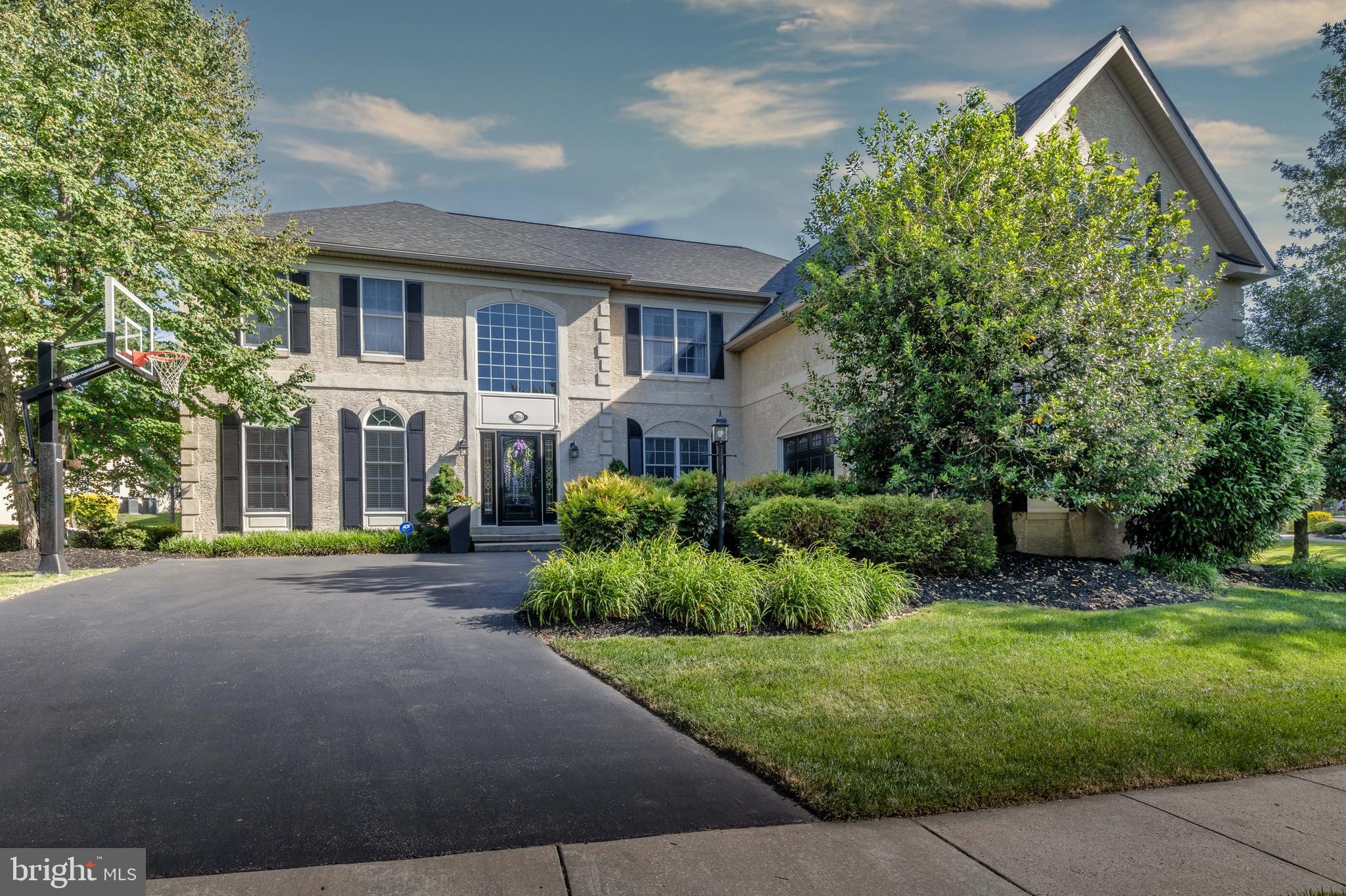 Welcome to 263 Rivercrest Drive, an exceptional estate home in the prestigious gated community, where elegant design, thoughtful upgrades, and a true country club lifestyle come together. Beautifully maintained and move-in ready, this home offers nearly 5,000 sft. of refined living space, a spectacular finished lower level and extended fenced outdoor living space.A grand two-story foyer welcomes with soaring ceilings, a graceful curved staircase, and an open balcony that overlooks the main living areas. Rich oak hardwood floors, wide hallways, and abundant natural light create a home that feels both spacious and inviting. The formal living room and elegant dining room, highlighted by distinctive bronze dandelion chandeliers, provide the perfect setting for holidays, celebrations, and family gatherings.At the heart of the home is a beautifully remodeled gourmet kitchen designed for those who love to cook and entertain. Premium Café appliances include a six-burner gas range, wall oven, microwave/convection oven, warming drawer, and dishwasher. A large marble island comfortably seats four and provides generous workspace, while the unique walk-in pantry features custom abundant shelving, a coffee bar and beverage refrigerator.The large family room is impressive and comfortable, featuring soaring cathedral ceilings, a dramatic floor-to-ceiling stone fireplace, and a stunning wall of windows. Three sets of doors open directly to the patio, creating an effortless connection between indoor and outdoor living.The backyard is truly a private retreat. Two magnificent Magnolia trees provide beauty and privacy under the natural canopy over the expansive patio. At its center is a six-person Hot Springs spa, inviting you to enjoy morning coffee, summer gatherings, or peaceful evenings beneath the stars. This outdoor oasis is one of the home's most memorable features.Dual staircases lead to four generously sized bedrooms, each with custom walk-in closets. The luxurious primary suite offers a private sitting area, two oversized walk-in closets, and a spa-inspired bath with dual vanities, an oversized walk-in shower, Jacuzzi soaking tub, and private water closet. A junior suite includes its own private bath, while the remaining bedrooms share a spacious Jack-and-Jill bathroom.The finished lower level is an entertainer's dream. A custom bar seats six and features a kegerator with draft tap, dual beverage refrigerators, sink, and extensive cabinetry. Multiple television viewing areas, divided by a sliding barn door, allow games or movies to be enjoyed at the same time. Play a game of darts or pool. The lower level includes a dedicated fitness room, a fully equipped craft or art studio with extensive cabinetry and work surfaces, a powder room, generous recreation space for a pool table or game room, and abundant storage.Additional features include a whole-house Culligan water treatment and conditioning system, Nest thermostats, ADT and Ring security, Wi-Fi-enabled video streaming, and lighting controls, recessed lighting with dimmers, a spacious mudroom with built-in storage, dual-zone heating and cooling, and an oversized two-car garage with epoxy floor and expansive shelving.Rivercrest offers rare exceptional homes. Residents enjoy a secure gated entrance, beautifully maintained grounds, snow removal, a clubhouse, community swimming pool, scenic walking trails through more than 50 acres of preserved open space, and the opportunity to enjoy Rivercrest Golf Club just steps away. Conveniently located from the restaurants, breweries, and vibrant nightlife of downtown Phoenixville, as well as Collegeville, King of Prussia, Valley Forge National Historical Park, and major commuter routes, this home combines luxury, comfort, and convenience in one remarkable location.This is more than an address. It is a gathering place where life is celebrated, and quiet evenings beneath the Magnolia trees become lasting memories.