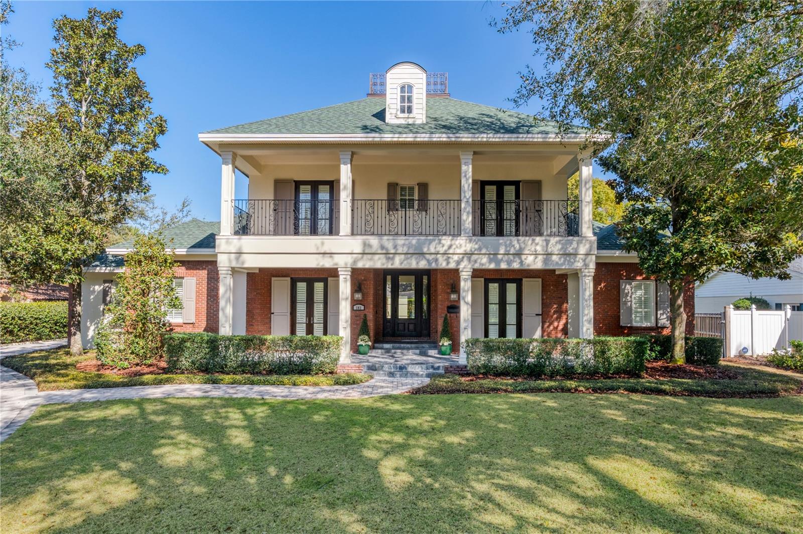 Grand Southern charm and architectural elegance define this stately residence in one of Winter Park’s most desirable neighborhoods, set along a quiet brick-lined street just steps from Lake Chelton.  Positioned on nearly half an acre, the home spans over 5,200 square feet, offering 5 bedrooms, 4.5 baths, a designated office, a large, versatile media/game room, a 3-car garage, and an expansive lanai with summer kitchen and resort style pool— all brought together in a smart well-planned layout ideal for effortless everyday living and exceptional entertaining.Step inside to a beautifully curated interior where rich architectural detail and livable design come together. Extensive custom millwork—seen in detailed moldings, trim work, and built-ins—adds depth and character throughout. The entry opens to gracious living and dining spaces, complemented by an impressive 550+ bottle temperature-controlled wine room.At the heart of the home, a beautifully appointed Kitchen, featuring white wood cabinetry, a six-burner gas range, an oversized quartz island, and a delightful breakfast nook that seamlessly connects to the family room featuring custom built-ins and fireplace—creating a natural gathering space.Tucked away, the first-floor primary suite offers a spacious sitting area, a beautifully customized closet with dressing area, and a luxurious bath with marble flooring, a large double-head walk-in shower, dual vanities, a free -standing tub, and built-in linen cabinetry—designed as a calming and private sanctuary.The first level also features a private guest bedroom with en-suite bath, creating an ideal setup for friends & family.A generously sized laundry room offers abundant cabinetry and exceptional storage, making everyday tasks feel effortless. Upstairs, three spacious bedrooms and two full baths provide comfortable accommodations, with two bedrooms opening through French doors to the front double balcony—perfect for enjoying peaceful treetop views.The back of the home unfolds around a beautiful pool and spa, with French doors from multiple rooms opening to the lanai and creating a natural indoor-outdoor connection. Retractable screens allow for year-round enjoyment of the well-appointed summer kitchen, making it ideal for both relaxed evenings and easy entertaining.Other notable highlights: a whole house natural gas generator, extensive brick paver driveway & motor court, automated driveway gate, integrated sound system, security cameras and new roof 2024.Lastly, this profound property offers top rated Winter Park schools and easy access to Park Ave, Downtown Orlando, Audubon Park Garden District and Baldwin Park.