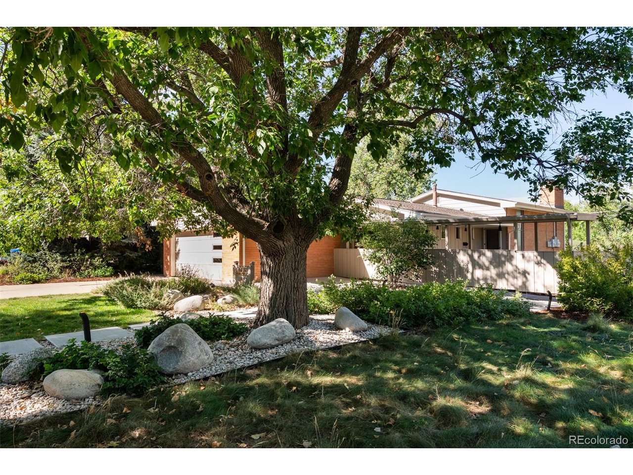 Situated on nearly 1/4 acre with panoramic views of the Rocky's, backing to DeKovend Park and the Highline Canal Trail, full glass rear, and original MCM features combined with perfectly era-appropriate updated bathrooms- This two-owner, MidMod home will have your jaw dropping at every turn. As you walk up to this home under the long, covered walkway, you feel you have entered into a lush, secret garden. Once you step inside you are surrounded by a multitude of midmod elements: bottle glass, floor to ceiling windows, ample natural light, brick walls, and warm wood details. Up to half stairs to the main level, you enter into the living room with floor to ceiling glass slider, cornered fireplace, and flow to the dining and kitchen. The kitchen still retains its original, hand crafted cabinets, and is drenched in sunlight with a sliding door to the side covered patio, and second massive glass slider on the rear of the home. Down a half level is the bedroom floor. With a large primary bedroom, full bath ensuite and retro -ified bathroom, and walk in closet. There are also two more large bedrooms, and a 3/4 bath (also retro-ified). The garden level is the grooviest place to hang! Surrounded by warm, original wood panels, bar (compete with saloon door and built in clock), another cornered fireplace, and a built in desk and shelves. This level has the 3rd retro-ified bathroom with extra built in storage, as well as the laundry room! If that wasn't enough to have you drooling, step out back to take in your panoramic views of the Rocky's, and revel in the sounds of nature in DeKoevend Park (100+ acres of open space) behind you. In addition- the Highline Canal is only steps away, connecting you in minute to a South Suburban Rec Center. This MCM home also boasts owned solar to nearly erase your electrical costs. This midmod has all the MCM features you yearn for+incredible views and unbeatable location packaged as a once in a lifetime opportunity to make this home, yours.