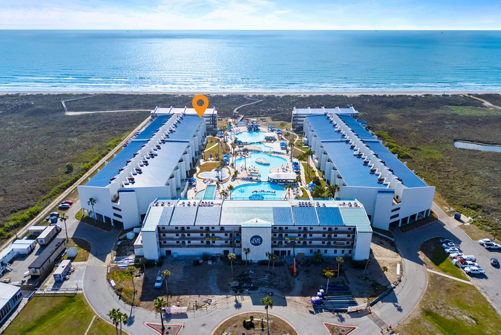Wake up to sweeping Gulf views and true resort living in this beautifully updated 2BR/2BA condo at Port Royal by the Sea. Ideally positioned on an upper-level end location closest to the beach, this unit captures stunning water, pool, and sunrise views from your private balcony. Inside, the open-concept living, kitchen, and dining area is designed for easy coastal living and entertaining, featuring tile flooring throughout, coastal-inspired finishes, and abundant natural light. The kitchen is updated with granite countertops, island, pantry, and plenty of storage. Offered fully furnished, this turn-key condo is ready for immediate enjoyment or rental income. The spacious layout includes split bedrooms for privacy, a comfortable primary suite, and in-unit laundry. Two assigned covered parking spaces are conveniently located just below. Port Royal is Port Aransas' premier resort community, offering a true vacation lifestyle with a tropical lagoon-style pool, water slides, splash pad, heated lap pool, hot tubs, swim-up bar, on-site restaurant, beach walkover, and full-service amenities. Whether you're looking for a personal getaway or an income-producing property, this is your opportunity to own a piece of the island lifestyle on Mustang Island.