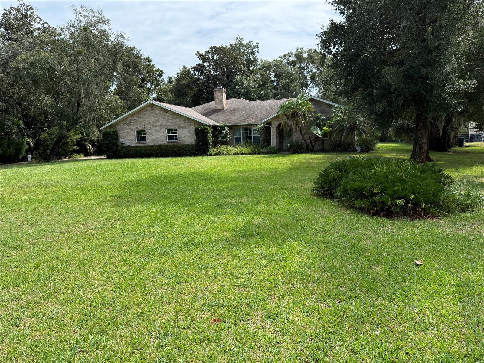 Quality Built brick home on 1 acre with mature landscaping and a wooded lot.  Quiet neighborhood with easy access to I-95 and shopping. Split plan. Great Room features coffered ceilings, and a stone wood burning fireplace.  Master suite bathroom has access from the spacious 2 car garage.  Enjoyable rear screened porch to watch the wild life frolic in the private wooded back yard.  Detached oversized 1 car workshop.  2 wells, one for irrigation and 1 for the house with a quality water softening system.  Central Vacuum, Security System and window treatments. Roof heavy architectural 130 MPH shingle in 2013, New AC system 2023, New refrigerator 2025. Survey available.