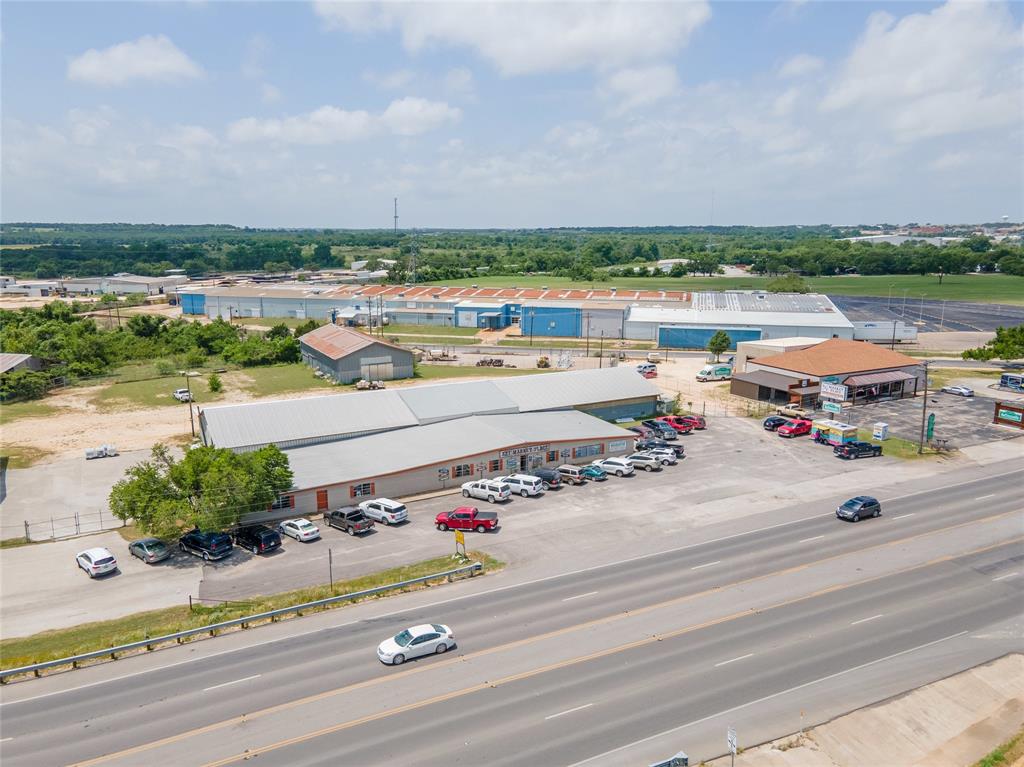 Prime commercial location with US 377 Highway frontage - endless possibilities and currently an income producing property that leases market space for vendors with more room on this property for expansion.  Several outbuildings, enclosed and open, city water and sewer, rail spur site at back that previously held 4 cars is not active and needs rehab.  Possibility of additional entry off Caporal Ave.   Currently 377 Market Place.
