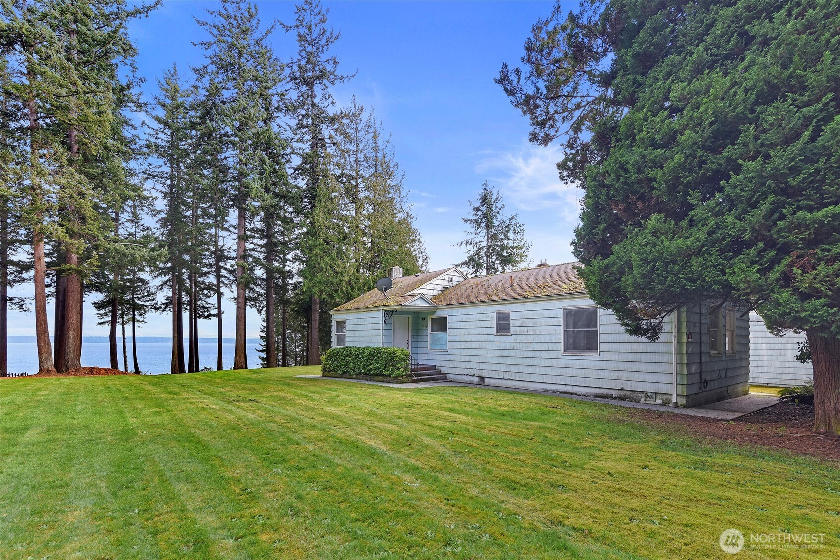 Set in the peaceful and picturesque community of Pilot Point, this rare opportunity invites you to restore a charming 1942 Craftsman or create your dream home on the private shores of the Puget Sound. The nearly 4-acre parcel features 127 feet of stunning high-bank waterfront with panoramic views of the shipping lanes and the Cascade Mountains. A spacious pasture-like lawn greets you near the road, while the driveway winds down to the home where the view dramatically unfolds. Wander through the forest to a quiet waterfront perch, complete with lawn chairs and a fire pit, perfect for taking in the sights and sounds of the Pacific Northwest. Seller-provided design renderings offer inspiration for a future home within the existing foundation footprint. Bring your vision and imagination to unlock the incredible potential of this truly special waterfront property.
