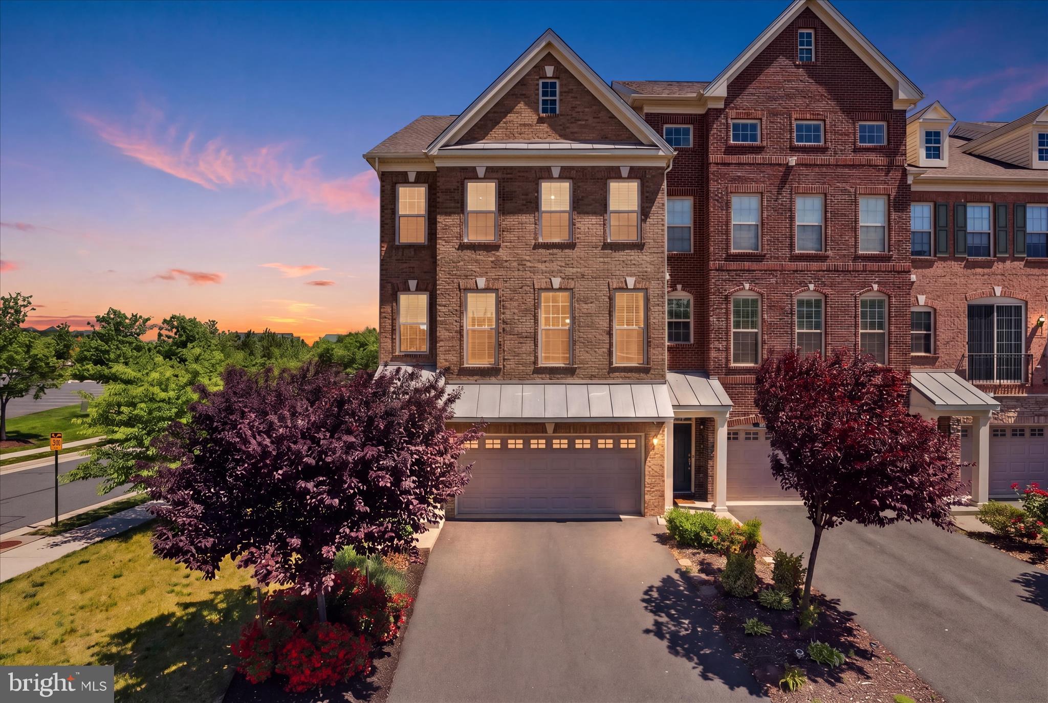 Welcome to this stunning and modern living in an exquisite 2-car garage end unit townhome, set in the highly sought-after Loudoun Valley community! You will be stunned by the gorgeous interior that exudes sophistication at every turn, from the elegant tones to the gleaming hardwood flooring. Tall ceilings with recessed lighting, and ceiling fans soar above the open-concept main gathering areas, while large windows bring in the brilliant sun and frame neighborhood views. The home welcomes you into an inviting foyer, the main level features a massive living room that flows into the dining area. The modern kitchen is a chef's delight! It features a double oven/microwave combo, Stainless Steel Appliances, a custom tile backsplash, a large pantry, and granite countertops, and tall cabinets providing both style and functionality. The countertops extend to the multi-seater breakfast island. The kitchen flows into family room areas creating an open and inviting space for both everyday living and entertaining. The breakfast area leads into a large and private Trex deck overlooking a pond. Perfect for outdoor barbecue parties or enjoying quiet morning coffee with serene views. The powder room completes the main level. The upper level features a grand Master suite with His and Her walk-in closets with custom built-ins that offer abundant storage space, ensuring your clothing and accessories are well-organized. The master bathroom features a dual vanity and stand-in shower with a bench. The two spacious guest bedrooms feature closets with built-in shelves. The guest full bathroom features a dual vanity and stand-in tub shower. The laundry room is conveniently located close to all the bedrooms. The bonus room is perfect for storage or can be used as a hobby space. The lower-level walk-out features a recreation room with a door leading to the private backyard. Fourth bedroom with attached full bathroom. The mudroom has custom cabinetry for extra storage and use. The highlight of this home is the serene backyard, which features a custom new expansive concrete porch, green space for gardening, and is fully fenced in, offering plenty of privacy, the perfect spot for outdoor entertaining and relaxation. Location-wise, this home has it all. Loudoun Valley offers wonderful community amenities that can't be beaten: including two fitness centers, three swimming pools, several playgrounds, pickleball/tennis courts, volleyball and basketball courts, a community center, and more; providing recreation options for everyone. Great commuter access makes it convenient for travel, with proximity to major commuter routes, top-notch schools, the new Ashburn Silver Line metro, and commuter bus lots. Situated nearby to the Brambleton Town Center, offering excellent shopping and dining options. This home truly offers a combination of luxury, convenience, and community amenities.
