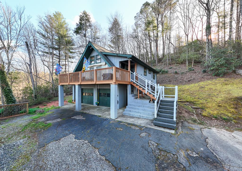 Located just minutes from downtown Robbinsville in the desirable High Splendor Community, this beautifully maintained three-bedroom, two bath home offers the perfect balance of comfort, privacy, and mountain living. Situated on two combined lots totaling 1.69 acres, the property provides stunning mountain views, private setting, and all accessible by a paved community road for year-round convenience. Step inside to find a warm and inviting interior featuring wood shiplap paneling throughout the main level, paired with clean drywall ceilings for a rustic yet refined feel. The living room centers around a cozy gas fireplace, creating the perfect space to relax after a day of exploring the surrounding mountains. Durable LVP flooring runs throughout the home, offering both beauty and low-maintenance living. The kitchen has been thoughtfully updated with modern appliances and upgraded countertops, making it both functional and appealing for everyday use or entertaining guests. The home is equipped with two water heaters, ensuring ample hot water for family and visitors, as well as a whole-house generator for added peace of mind in any season. Downstairs, the basement features a two-car garage along with a dedicated workshop area, providing excellent storage and workspace for hobbies, tools, or outdoor gear. Whether you're a full-time resident or weekend adventurer, this home is designed to accommodate your lifestyle. Perfectly suited as a permanent residence, mountain getaway, or rental investment property, this home places you in the heart of an outdoor enthusiast's paradise. Enjoy easy access to nearby attractions including Lake Santeetlah, Joyce Kilmer Memorial Forest, the legendary Tail of the Dragon, Cherohala Skyway, and the Nantahala River. From fishing and hiking to scenic drives and motorcycle adventures, this location offers something for everyone.