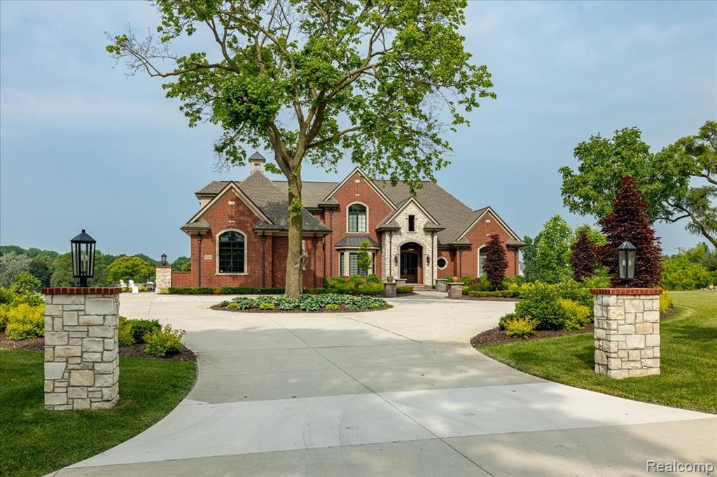 Welcome to this stunning Cranbrook custom-built all brick estate, completed in 2021 and set on 5.5 beautifully landscaped acres just 1.2 miles from downtown Plymouth. This unique property features over $500K in professional landscaping, a private pond with island, sunset views, and a privately owned bridge. With 4,827 sq ft above grade and 1800 sq ft in the finished walkout lower level, this home offers exceptional space and luxury. The open-concept main floor is ideal for entertaining and daily living, with wide plank wood floors, Anderson windows, programmable shades, and serene pond views from the kitchen, dining, and family rooms. The chef’s kitchen boasts Thermador appliances, a massive gas range, quartz counters, prep island with disposal, and extra-large walk-in pantry. The mudroom includes vertical cubbies for coats and dedicated shoe storage. The main laundry offers a fridge, sink, and generous counter space—one of three laundry rooms. The main floor Primary suite has radiant heat in the bedroom, bath, and walk-in closets. The spa-like bath features a Euro shower for two, impressive dual vanities, and huge closets with custom built-ins. All 5 bedrooms have walk-in closets, and the home includes 4 full and 2 half baths. A separate in-law apartment offers a full granite/stainless kitchen, living room, bedroom, walk-in closet, and private anytime entrance. The finished walkout includes 10' ceilings, luxury vinyl floors, granite wet bar, rec space, full bath with Euro shower, gym, and amazing pond views. Outdoor living features a covered Lanai with fireplace, TV, stamped concrete, and expansive patios. Extras: 4-car garage with epoxy floors and cabinets, stately circular drive with landscaped center, whole-house generator, Sonos sound system, full sound insulation, and the rare option to build a second home on additional lot. With radiant heat, 4 fridges, Michael Phelps 18' swim spa and high-end finishes throughout, this home defines modern luxury.