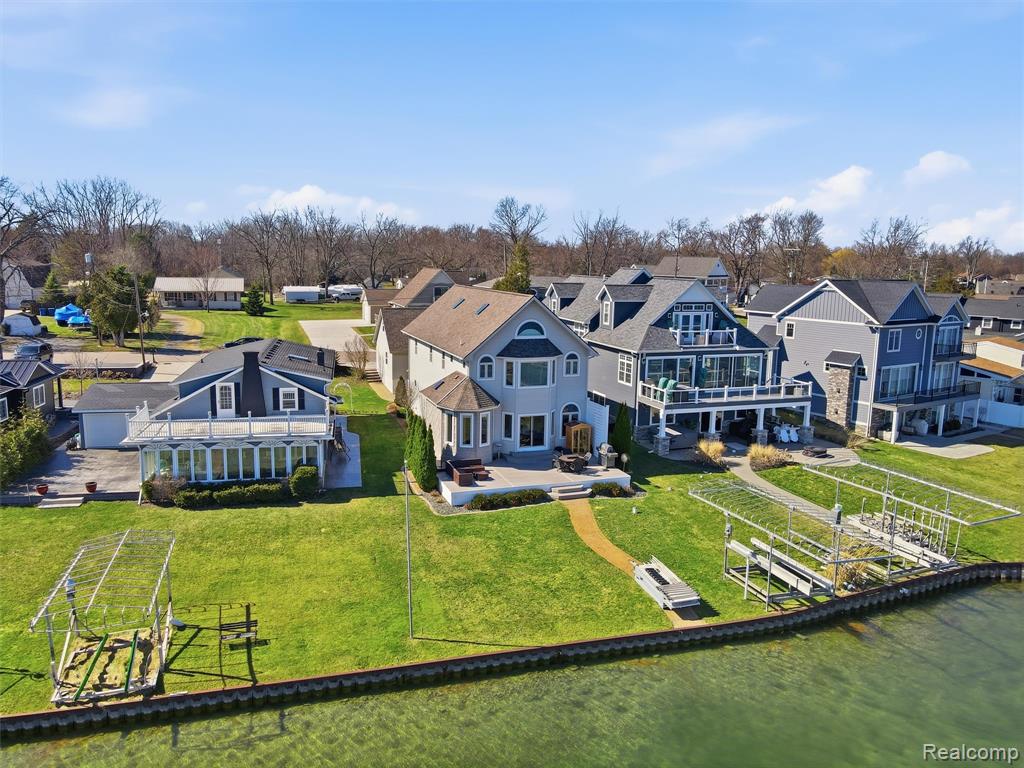 Lakefront Living on All-Sports Lake Fenton. Experience the beauty of lakefront living in this spacious 5-bedroom home on all-sports Lake Fenton in Fenton. Offering 3,495 square feet of living space and 43 feet of prime lake frontage, this property delivers stunning water views, generous living areas, and the perfect setting for entertaining or everyday comfort. The open-concept main level centers around a beautifully designed kitchen featuring abundant cabinetry, granite countertops, a large center island, stainless steel appliances, a built-in stovetop and oven, and a stylish gray tile backsplash. A raised bar provides additional seating for guests, while the nearby dining area includes a convenient wet bar—perfect for hosting gatherings. The kitchen flows seamlessly into the dining and living spaces, where an abundance of windows fills the home with natural light and showcases the lake views. Upstairs, you’ll find spacious bedrooms and the convenience of a second-floor laundry room. The primary suite offers vaulted ceilings, a large bay window overlooking the water, and a private bath complete with a double vanity and step-in glass shower. An additional finished level above provides flexible space ideal for a den, home office, studio, or private retreat. Fresh carpet and hardwood flooring run throughout the home, adding warmth and style. Outdoor living is just as impressive, featuring a beautiful deck off the back of the home—perfect for relaxing or entertaining while enjoying the lake scenery. A paved walkway leads directly to the water, where you can take full advantage of your 43 feet of lake frontage. Additional highlights include a detached 2-car garage with attic storage above, plus an unfinished basement offering 1,422 square feet of additional storage space. Whether you're looking for year-round lake living or the perfect place to entertain and unwind, this Lake Fenton home offers space, views, and an unbeatable waterfront lifestyle.