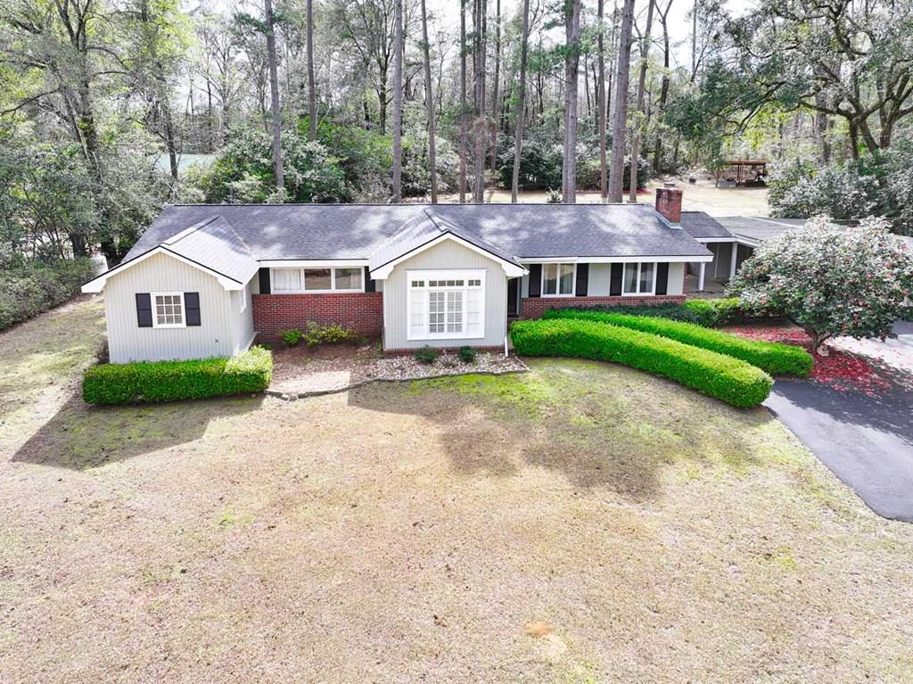 Live right where you want to be. 123 W Club Drive offers the rare opportunity to enjoy space, privacy, and convenience all in one. Located just around the corner from Glen Arven Country Club and only minutes from downtown Thomasville, schools, shopping, dining, and everything else Thomasville has to offer, this freshly renovated 3-bedroom, 2-bath home places you in the heart of everything while still giving you room to breathe. Situated on 1.3 acres and backing up to plantation property, the setting provides a peaceful, private backdrop that's hard to find in town. Whether you're enjoying a quiet evening outdoors or hosting friends and family, the expansive backyard offers endless possibilities. Inside, the home has been thoughtfully updated to create a fresh, move-in-ready feel. The completely redesigned kitchen features new cabinetry, quartz countertops, and all new appliances—perfect for everyday living and entertaining. New luxury vinyl plank flooring flows throughout, creating a clean and cohesive look. The living room centers around a wood-burning fireplace that has been professionally cleaned and inspected, adding warmth and character. A vaulted flex room offers versatility to fit your lifestyle—ideal as a formal dining space, home office, or additional sitting area. One of the standout features is the bright sunroom overlooking the private backyard. It's the perfect space for morning coffee, reading, or simply enjoying the peaceful view of the land behind you. Major upgrades provide added peace of mind, including a new roof, new HVAC ductwork, tankless water heater, and updated lighting throughout. The property also includes a wired storage building and wired shed, offering additional flexibility for hobbies, projects, or storage needs. This home combines modern updates, generous acreage, and one of Thomasville's most desirable in-town locations—an exceptional opportunity for those seeking comfort, convenience, and privacy.