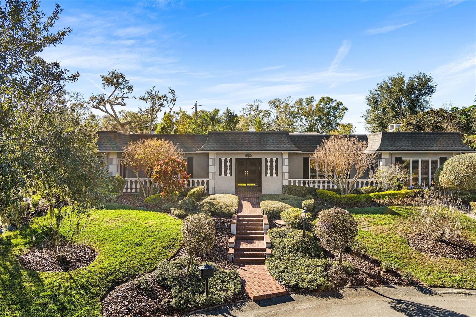 Enjoy worry-free living and elevated entertaining in this French-inspired estate, featuring a whole-home generator and a completely remodeled, show-stopping Chef's Kitchen —perfectly suited for Florida living. Tucked away on a quiet cul-de-sac in the highly desirable Scott Lake area, this exceptional residence offers deeded lake access and scenic lake views from select areas of the home, blending privacy, elegance, and lifestyle.A stately brick walkway, lush landscaping, and classic brick terraces create a striking first impression. Through grand double doors, the home reveals a refined showcase of craftsmanship with plantation shutters, custom millwork, and architectural detail throughout. This thoughtfully designed 4-bedroom, 3.5-bath residence balances timeless character with modern upgrades.The marble-tiled foyer with grasscloth wallpaper sets a rich, welcoming tone, leading to a charming step-down entertaining space and formal dining room accented by leaded-glass windows. Brazilian cherry hardwood floors, crown molding, and soft neutral tones enhance the open-concept living areas, all anchored by the fully remodeled chef’s kitchen. Designed for both daily enjoyment and elevated entertaining, the kitchen features an oversized quartz waterfall island, two-tone custom cabinetry, and a concealed custom pantry, complemented by a curated suite of premium appliances by Sub-Zero, Thermador, Bosch, and Rangemaster. A butler’s pantry with a second Sub-Zero refrigerator further enhances functionality and hosting ease.The primary suite offers a peaceful retreat with serene lake views, a spacious walk-in closet, and a beautifully updated spa-style bath. Additional bedrooms include en-suite bathrooms, while a flexible fourth bedroom is ideal for guests or a home office.Outdoor living truly shines on the screen-enclosed swimming pool and lanai, providing a private, low-maintenance setting ideal for year-round enjoyment and entertaining, while enjoying fresh fruit from Papaya, Avocado, and Lemon trees.  The sparkling heated saltwater pool creates a tranquil retreat for relaxing or hosting in comfort and privacy. With two new A/C units and the whole-home generator, this home delivers confidence, comfort, and peace of mind in every season.Homes of this caliber—offering architectural character, modern systems, and deeded lake access in such a private setting—are seldom available. This is a home that must be experienced in person. Schedule your private showing today and discover the lifestyle this Scott Lake estate provides.