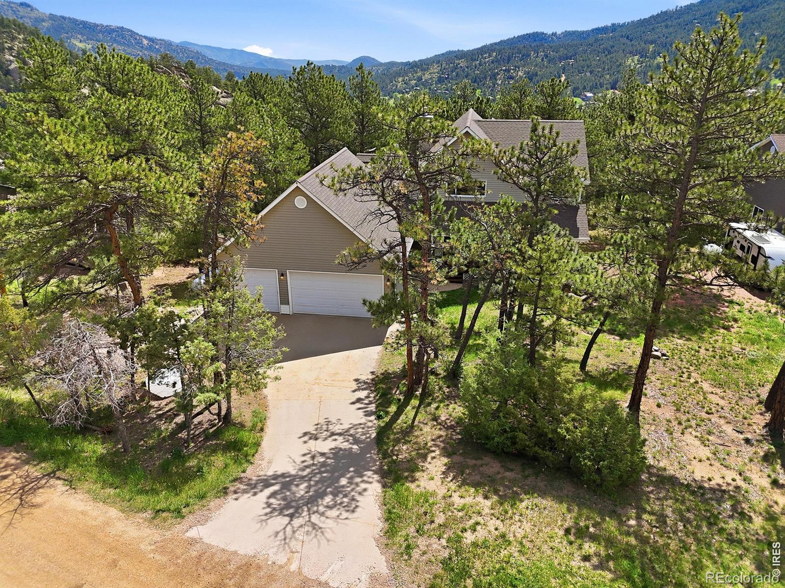 Welcome to 256 Choctaw Rd, a spacious mountain home in the sought-after Pinewood Springs community offering a rare combination of usable outdoor space, flexible living areas, and thoughtful upgrades. Pinewood Springs residents get special access to private natural springs, scenic walking paths, and a welcoming neighborhood atmosphere. The bright, open main level features soaring ceilings, beautifully refinished hardwood floors, and a spacious kitchen with durable Cambria quartz countertops, abundant prep space, and an easy connection to the dining area and outdoor balcony-ideal for everyday living and entertaining. The entire upper level is dedicated to a private primary suite, creating a true retreat with vaulted ceilings, a generous walk-in closet, a large bathroom with heated floors, and a versatile loft-style office or bonus area. Downstairs, the open finished basement adds even more usable living space, including a theater setup and plenty of room for a recreation area, home gym, guests, or additional work-from-home space. Outside, the approximately 0.88-acre lot is exceptionally flat and usable for a foothills property, giving you room to entertain, relax, play, or simply enjoy the mountain setting. The oversized heated three-car garage-one of the largest on the street-provides incredible space for vehicles, storage, hobbies, and mountain gear, while an EV charger adds modern convenience. With its usable lot, impressive garage, private primary retreat, finished basement, and inviting community, 256 Choctaw Rd offers a Colorado mountain lifestyle without sacrificing the space and functionality of an everyday home.