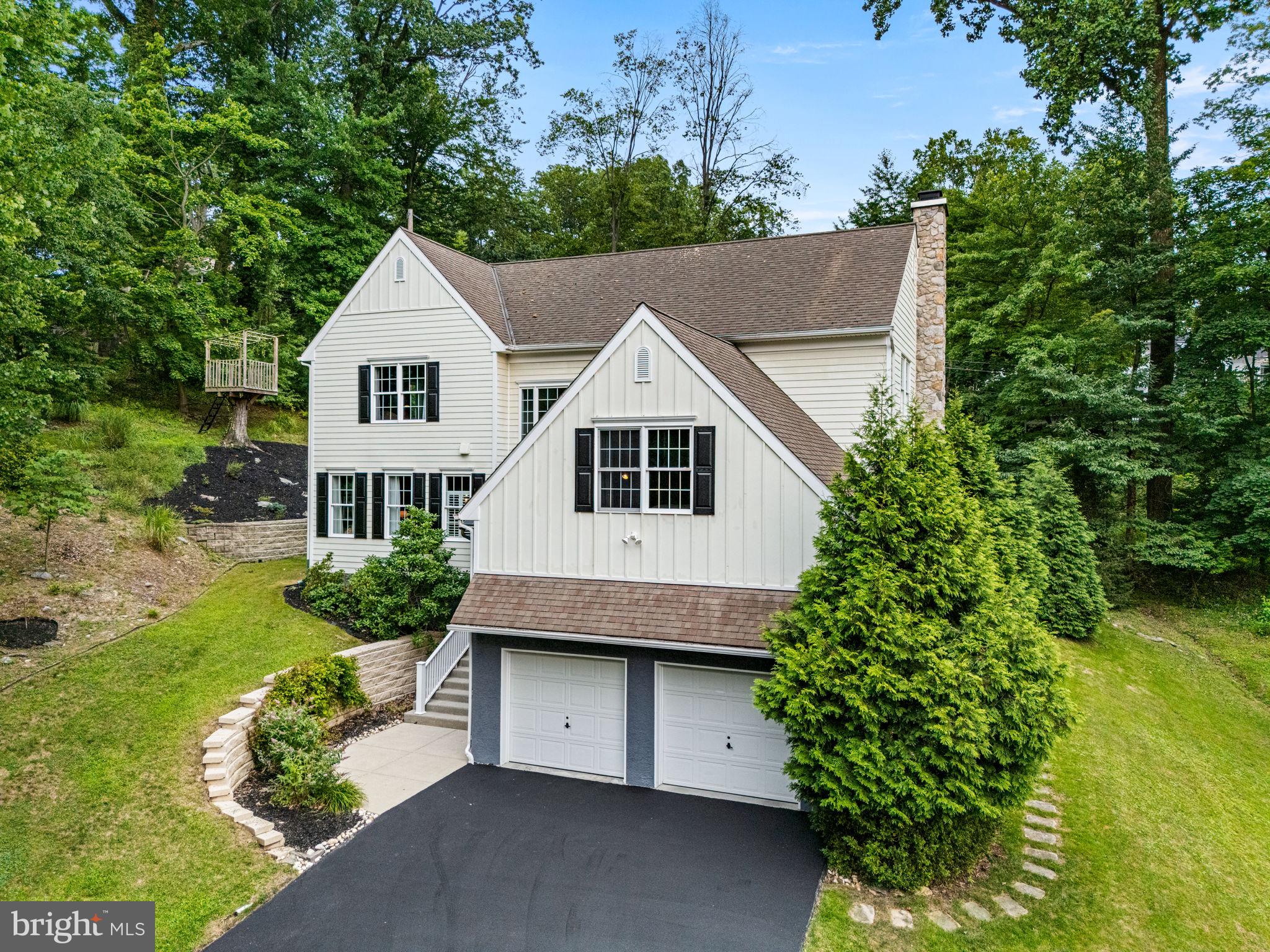 This magnificent hillside home was custom crafted with architectural excellence on a wooded lot in the highly sought after Valley Hills neighborhood with attention to detail and a sophisticated design. It is an immaculate, move in ready and pristine condition inside and outside. The home is nestled on just over a third of an acre lot with beautiful serene views and natural wooded buffers creating your private oasis. Enter through the charming and inviting covered front porch to the stunning two-story foyer showcasing the split staircase, gorgeous hardwood flooring and a stately second story window providing tons of natural daylight. Throughout the home you will find an open concept living floor plan, 9' volume ceilings, sun-drenched rooms, and rich hardwood flooring designed with timeless elegance. The fantastic family room features built in bookshelves, accentuated with a floor to ceiling gas stone fireplace and a raised hearth. There is also a cozy convenient beverage nook. The wall of windows highlights the peaceful wooded vista of the exquisite backyard. The chef's gourmet kitchen is the heart of the home designed for entertaining with the amazing vaulted ceilings, skylights, lots of natural wood raised panel cabinetry with crown molding, including a large pantry, granite counters, center island with bar height seating and premium stainless steel appliances. The kitchen side door leads to the 26' low maintenance composite deck ready for outside dining and entertaining or simply relaxing under the stars in the newer jacuzzi-spa hot tub. The gracious and elegant dining room has plenty of space for large family gatherings on the holidays, and offering lovely views of the tranquil backyard. The luxurious living room is simply breathtaking, and can be used as a guest bedroom with an adjacent completely custom full bathroom that is conveniently located on the main living level of the home offering comfort and versatility. The spa-inspired main bedroom suite has duel generous walk-in closets and a sumptuous main bathroom featuring  a double vanity, separate opulent shower and a stand-alone soaking tub. The laundry room with the new dryer and a washer set on pedestals is located  on the upper level for accessibility and convenience. There are three additional remarkable bedrooms, a splendid hall full bathroom with a dual vanity, and a large separate walk-in storage room. The enormous walk-out basement has so much potential with three separate massive areas that can become a fully equipped workout wellness retreat room, media entertaining lounge, and a large playroom with tons of extra storage space. The possibilities are limitless with the gigantic lower level. The attached oversized two car garage with a brand new asphalt driveway, also has plenty of storage space. The home is fitted with energy-efficient two-zone heating and central A/C systems, a home security system, and an integrated whole-house backup generator. The property has extensive hardscaping and landscaping with beautiful gardens. It is situated within the highly sought-after, top-ranked Tredyffrin-Easttown School District. It is also within walking distance of Friendship Park, Woodbine Park and the Paoli train station offering easy commuter access to Philadelphia, New York, and Washington D.C. It sits just minutes away from Valley Forge National Park, Airdrie Forest Preserve, King of Prussia Mall, and local Main Line shopping and dining. Don't miss the opportunity to view this truly spectacular home! Check out the icon links above for the 3D Walkthrough Tour and Video!