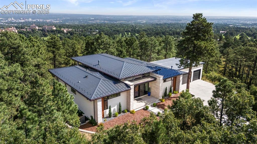 A rare fusion of cutting-edge design and serene natural beauty, this architectural masterpiece crowns the coveted Broadmoor Hotel enclave. Completed in 2020 by acclaimed Acuff Homes, the residence offers 4,864 square feet of sophisticated living space situated on 2.12 acres suspended amid the treetops, with panoramic vistas that create a true sanctuary. Inside, soaring ceilings and a seamless open plan unite the gourmet kitchen, dining area, and great room. Expansive multi-slide glass doors blur the line between indoors and out, opening to an impressive covered deck that captures the surrounding landscape. The primary suite commands nearly half of the main level—a private oasis with its own deck access. The spa-inspired bath showcases floor-to-ceiling designer tile, dual floating vanities, dual shower heads and a overly generous custom dressing room with built-in vanity.
The walk-out lower level is equally refined, hosting three additional bedrooms, a media lounge, and flexible space for game tables or a home theater. Every detail has been curated, from a hidden playroom beneath the stairs to the perfect siting of the home for effortless indoor-outdoor living.
For those seeking an exclusive lifestyle, a Broadmoor Golf Club membership is available, adding resort-style privileges to this already incomparable retreat