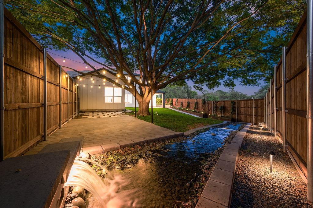 ***EXCLUSIVE FOR THIS HOME - LENDER-PAID TEMPORARY RATE BUY-DOWN - ask for details***  Nestled on a sprawling corner lot in the heart of East Dallas, this stunning 2022-built JLD Custom Home offers luxury, privacy, and over $150K in upgrades. Thoughtfully designed with no neighbors behind or on one side, this gently lived-in home features 3 patios - 1 covered, 1 stamped concrete and the third - a tile patio under one of the city's designated historic oak trees, and a serene self-filling stream with a waterfall, creating a backyard sanctuary that's ideal for unwinding or hosting a barbeque. A yard-length planter with seasonal blooms and integrated water lines ensures effortless landscaping.  Inside, you'll find vaulted ceilings and abundant natural light streaming through oversized windows. The open-concept living, dining, and kitchen areas are perfect for both everyday living and entertaining. The chef’s kitchen is as pretty as it is functional, featuring high-end appliances, custom cabinetry, a large island, and ample storage.The first floor also has a dedicated home office, ideal for remote work, and a spacious primary suite with a spa-like bath and custom walk-in closet. A secondary bedroom, positioned away from the primary suite, offers privacy for guests or family.Upstairs, you’ll find additional bedrooms and a spacious game room, providing plenty of room for relaxation and recreation.
Located just minutes from White Rock Lake, scenic trails, and vibrant local dining, this home offers the best of Dallas living - blending elegance, comfort and convenience in one perfect package.