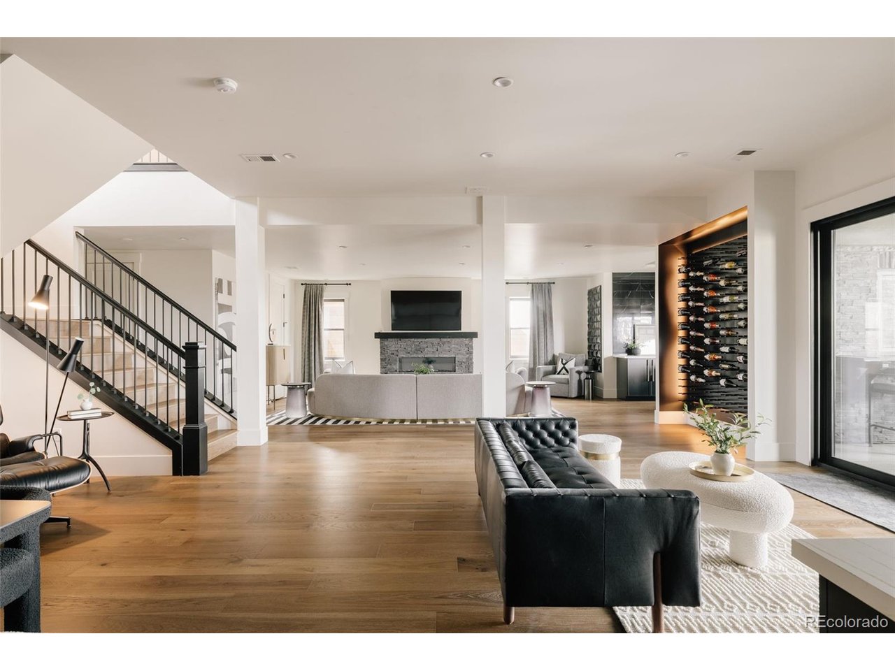 Award-winning Modern Mountain home-featured on HGTV's Rock the Block-on a quiet cul-de-sac in the gated Rookery at Heron Lakes. The home makes a statement with soaring 5" beetle-kill pine vaulted ceilings, herringbone hardwood floors, a sleek linear gas fireplace & a striking RH chandelier. Motorized blinds & expansive windows flood the open-concept main level with light while framing serene views. The chef's kitchen is a true centerpiece, blending design & performance with porcelain & quartz countertops, dark Emtek hardware with inset pulls, a 60" Ilve dual-oven gas range, Dacor refrigerator, freezer, dishwasher, built-in steam oven & a boutique-style pantry concealed behind rounded solid wood doors. Seamless indoor-outdoor living unfolds through expansive accordion doors opening to a covered deck with sweeping views of Lone Tree Reservoir, the Rookery & the Rocky Mountains-an exceptional setting for both quiet mornings & sunset entertaining. The main level hosts three ensuite bedrooms, including a luxurious primary retreat with radiant heated bathroom floors, a boutique custom closet & private laundry-one of three laundry areas throughout. A designer ombre bedroom adds a distinctive, curated touch. The walk-out lower level is designed for entertaining with a full second kitchen (Ilve range, Dacor appliances), a theater room with cork walls, tiered seating & custom lighting & a climate-controlled gym with overhead door access. Outdoor spaces rival a private resort with custom landscaping, locally sourced boulders, a water feature, private basketball court, putting green & turf yard with integrated drainage. The oversized garage features epoxy floors, built-in storage & a 240V EV outlet. Enjoy TPC golf privileges (full deeded membership) & access to resort-style amenities to the Golf Course, clubhouse, pool, fitness center, trails, dining, boating & over 130 acres of open space-an elevated lifestyle within one of Northern Colorado's most exclusive gated communities.