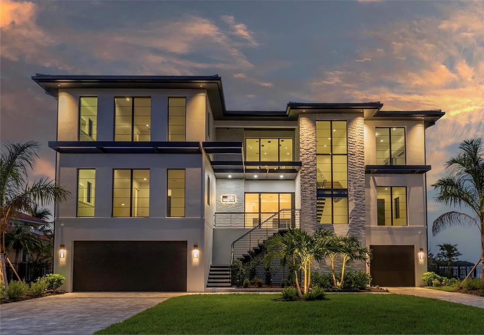 Crafted for those who demand the extraordinary. This one of a kind residence is located at the end of a private cul-de-sac in the exclusive Venetian Isles. Built by the renowned Tide Homes, Tampa Bay's premier estate builder, you'll find a sanctuary of sophistication and style. With five spacious bedrooms and five-and-a-half bathrooms, this home was designed for both entertaining and everyday living. From the moment you step through your modern oversized pivot front door, you’ll be captivated by the soaring 22-foot ceilings in the grand entryway and the stunning, handmade temperature-controlled wine cellar with a 480-bottle capacity—perfect for celebrating life’s special moments.
The heart of the home is the showstopping chef’s kitchen, featuring top-of-the-line appliances, custom cabinetry, and a massive island that’s ideal for hosting dinner parties or casual gatherings. Hidden behind a discreet door is the “messy kitchen” (butler’s pantry), complete with a separate fridge/freezer, dishwasher, sink, stone countertops, and ample storage, so you can entertain effortlessly while keeping the main kitchen pristine. Expansive impact windows and sliders flood the home with natural light and frame breathtaking views of Tampa Bay and St. Pete from nearly every room. But the true Paradise is the rooftop terrace, where you can sip your morning coffee or experience the sunset as the sky transforms into a masterpiece of color.
The third-level Flex space is an entertainer’s dream, with pocket sliding doors that open to a sprawling terrace, seamlessly blending indoor and outdoor living. This space features a striking five “cloud” ceiling design, a built-in wet bar with a wine fridge, mini fridge, custom cabinetry, recessed LED lighting, and sleek stone countertops. A dedicated stone TV wall with a floating cabinet completes the room, making it the ultimate spot to relax or host guests. The primary suite is a private retreat, enter through your French doors and find two separate custom walk-in closets, and a spa-like bathroom with separate sinks, backlit mirrors, a dedicated makeup station, a soaking tub integrated into the shower area, and a private water closet with a state-of-the-art smart toilet.
The ground level is a private oasis with an unmatched outdoor living area featuring approximately 2,000 sf of covered space showcasing level 5 ceilings, stone accents, recessed lighting, TV wall, and cabinetry.  The heated pool, hot tub, sun shelf, and fully equipped outdoor kitchen make every day feel like a vacation. Whether you’re grilling for a crowd or enjoying a quiet evening under the stars, this home was designed for effortless indoor-outdoor living. Need to work from home? A dedicated office space offers the perfect balance of comfort and productivity without having to sacrifice a bedroom. And with an elevator connecting all levels, every part of this home is easily accessible.
Located just minutes from downtown St. Pete, you’ll enjoy the best of both worlds—peaceful waterfront living and easy access to world-class dining, vibrant nightlife, and cultural hotspots. Thoughtfully designed with high-end finishes and luxurious details throughout, this home is as functional as it is beautiful. Whether you’re hosting a rooftop party, unwinding by the pool, or simply soaking in the stunning views, this home is all about living your best life. Don’t miss your chance to own one of St. Pete’s most spectacular homes—this is coastal living at its finest!