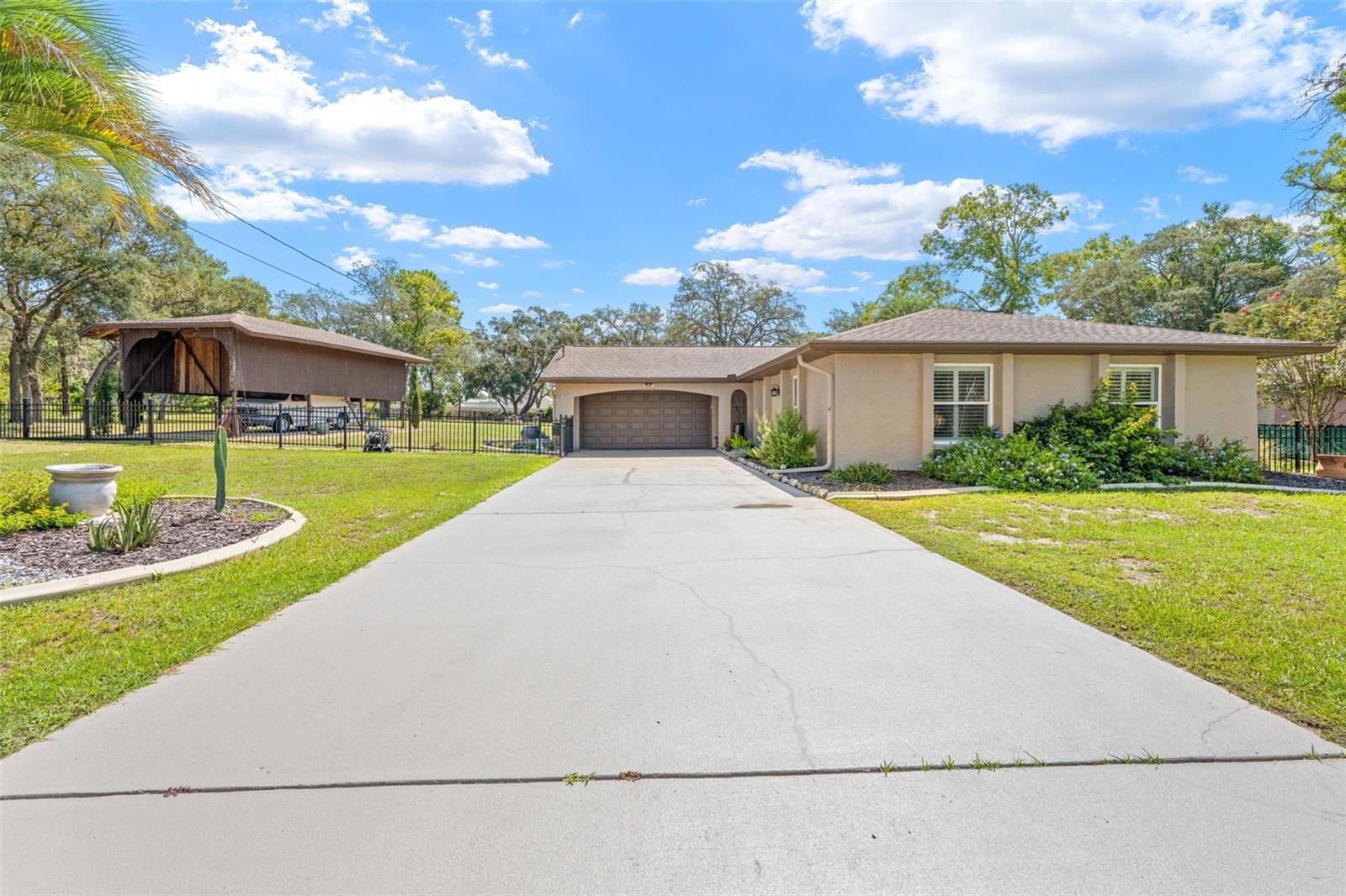 SELLER OFFERING BUYER INCENTIVES $2500! Looking for a home with character instead of cookie cutter? One that still boasts of beautiful trees on over ONE ACRE? One that already has a SALTWATER POOL? Then WELCOME HOME to this beautifully remodeled 3-bedroom, 3-full-bath 3 CAR GARAGE home situated on a beautifully landscaped 1.10-acre double lot. UPDATES: NEW HVAC - 2024NEW ROOF 2017NEW WATER HEATER- 2025NEWLY PAINTED 2025With an impressive list of features--including a private saltwater pool, DETACHED GARAGE/WORKSHOP, RV/boat parking, and spacious indoor and outdoor living areas--this property offers the perfect combination of comfort, privacy, and entertaining space.Step inside to an open, spacious floor plan enhanced by high ceilings, a wood-beam ceiling, ceramic tile throughout, and a stunning wood-burning STONE FIREPLACE. Large triple glass sliders provide beautiful views of the pool and fill the living space with natural light, creating a bright and welcoming atmosphere.The remodeled kitchen features granite countertops, a gorgeous backsplash, breakfast bar, BUILT IN DESK, and plenty of storage. It opens seamlessly to the nook, great room, and dining area, making it ideal for everyday living and entertaining. The nook includes built-in cabinetry, a granite SERVING BAR, and additional storage.The primary bedroom features an ensuite bathroom with a walk-in shower. The second bathroom offers beautiful wood cabinetry, granite countertops, and a shower/tub combination. A convenient third full bathroom is located in the garage providing easy access from the pool area or a quick shower after outdoor activities.Step outside to your own private oasis! The large 20' x 12' covered lanai provides plenty of space for relaxing, dining, and entertaining beside the private saltwater pool. The fully fenced yard offers privacy and is ideal for families and pets. There's even a small fenced area with RAISED GARDEN BEDS and an OUTDOOR FIRE PIT for enjoying evenings under the stars.For the hobbyist, outdoor enthusiast, or RV/boat owner, this property offers incredible storage and parking options. In addition to the 2-car attached garage there is a third detached garage with air conditioning, plus a large RV carport with water and electricity hookups to keep your RV, camper, or boat protected from the sun and elements.All of this is located in a convenient area close to shopping, restaurants, movies, and hospitals, while still offering plenty of space and privacy.