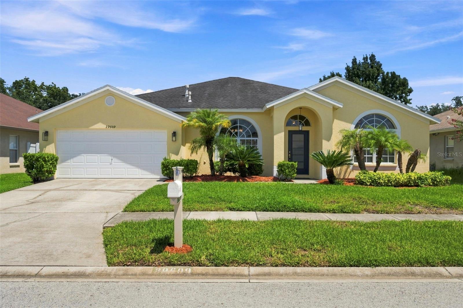 Welcome to 29609 Eagle Station Drive, a beautifully maintained 4 bedroom, 2 bathroom home offering an open layout, quality updates, and exceptional outdoor living in the heart of Wesley Chapel. Vaulted ceilings, oversized arched windows, and abundant natural light create a bright, inviting atmosphere, while rich wood flooring adds warmth throughout the main living areas.The versatile floor plan includes a formal dining room, spacious living room, cozy café dining area, and an additional flex space perfect as a second family room, home office, or playroom. The updated kitchen features white cabinetry, quartz countertops, subway tile backsplash, stainless steel appliances, a gas range, breakfast bar seating, and views of the backyard.The spacious primary suite offers vaulted ceilings and an updated en-suite bathroom with dual quartz vanities and a beautifully renovated walk-in shower.Step outside to enjoy the fully screened, extended lanai- an ideal space for relaxing or entertaining- complete with an outdoor serving station, utility sink, and multiple seating areas. The oversized backyard provides plenty of room for pets, play, gardening, or even a future pool.Recent updates include a 2015 roof, 2013 HVAC, 2023 water heater, fresh interior and exterior paint (2024), and new shades in the kitchen, bathrooms, and lanai.Located in Meadow Pointe II with no HOA, residents enjoy access to a community pool, splash pad, clubhouse, playground, tennis and pickleball courts, and basketball courts. Conveniently located near top-rated schools, hospitals, Tampa Premium Outlets, The Shops at Wiregrass, dining, entertainment, and major highways, this home offers the perfect blend of comfort, convenience, and Florida living.Schedule your private showing today!