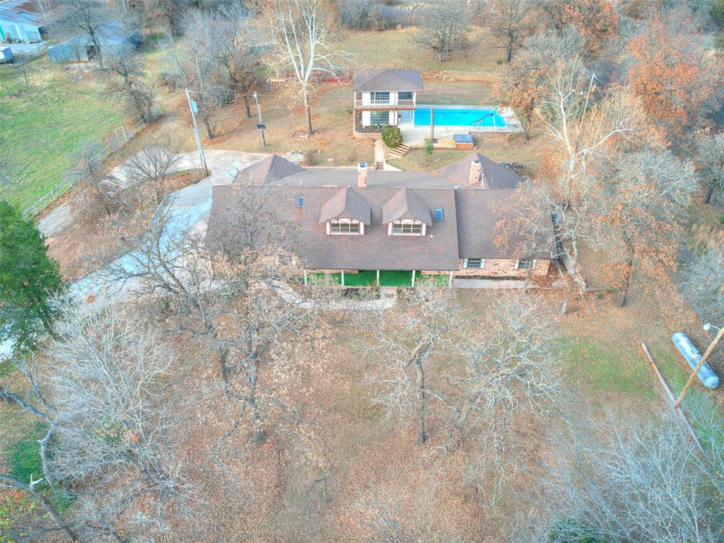 Welcome Home!! This home literally has it all! It has a newly updated unground pool with new equipment,a  700 sq ft pool house with bathroom and sinks upstairs and downstairs not included in the sq footage of the home, a HUGE barn with pipe rail fencing, a large-welcoming front porch and lots of room to roam. The back yard host a raised bed garden, a storm shelter, the pool with cabana, barn, along with many mature gorgeous trees! You will find a freshly painted inside with plenty of room for the whole family plus some with 4 bedrooms and 4 bathrooms in addition to a bonus room upstairs with its own bath!  2 living rooms, 2 dining room, and a wetter in the living room!! The Primary suite is so spacious with a gas fireplace, huge walk in closet and a massive bathroom! New appliances in the kitchen with plenty of storage! This is such a wonderful property with too many amenities to list!  This home is being sold as is!